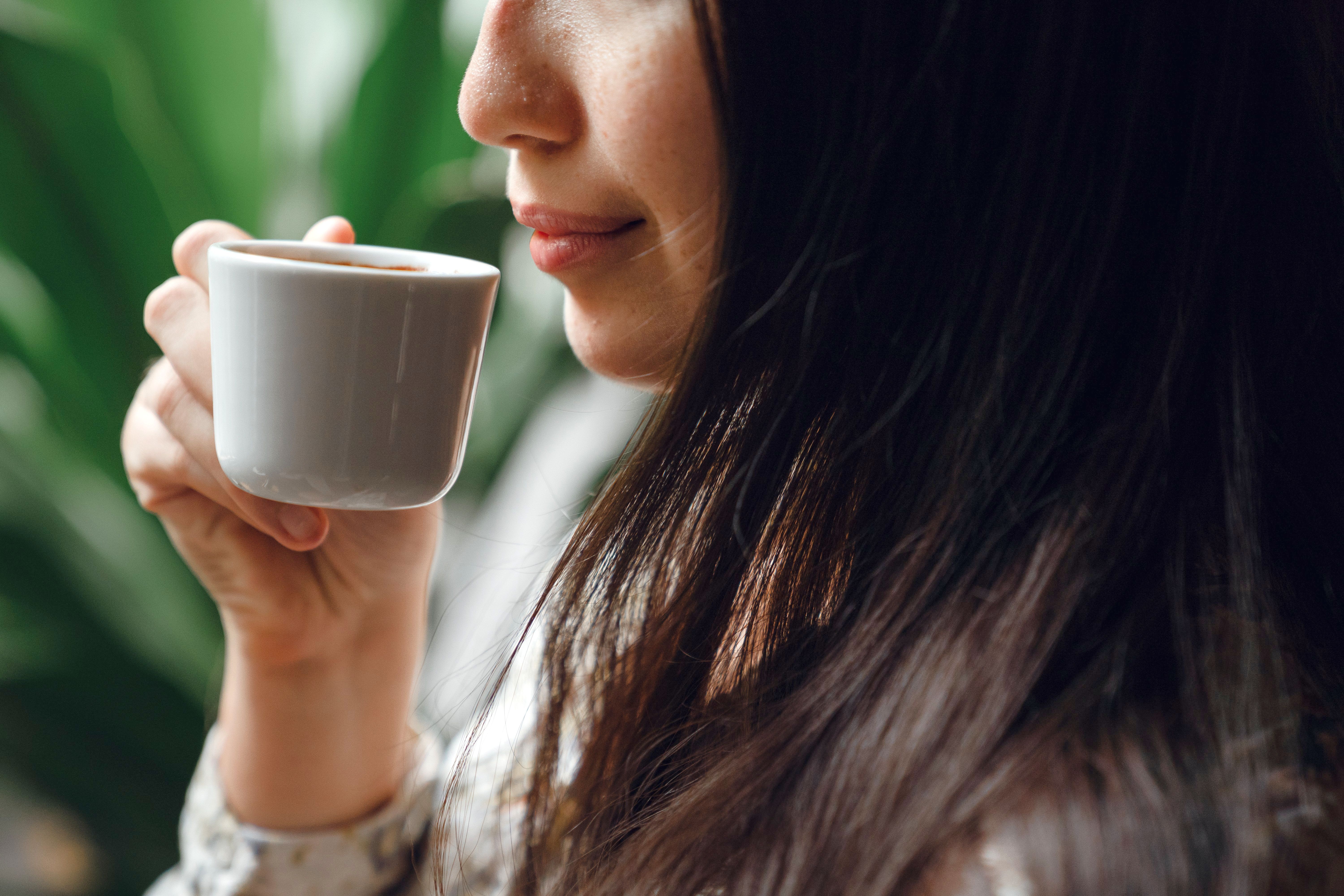 Woman smelling coffee