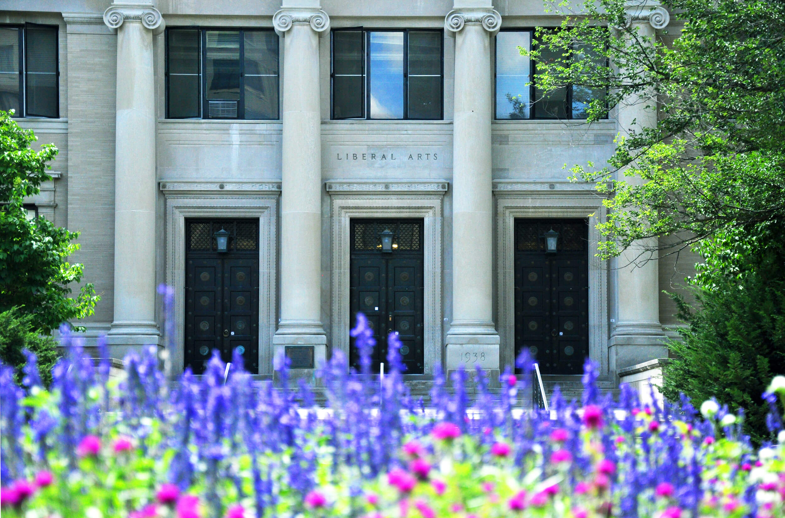 Sparks Building entrance with purple flowers in the foreground