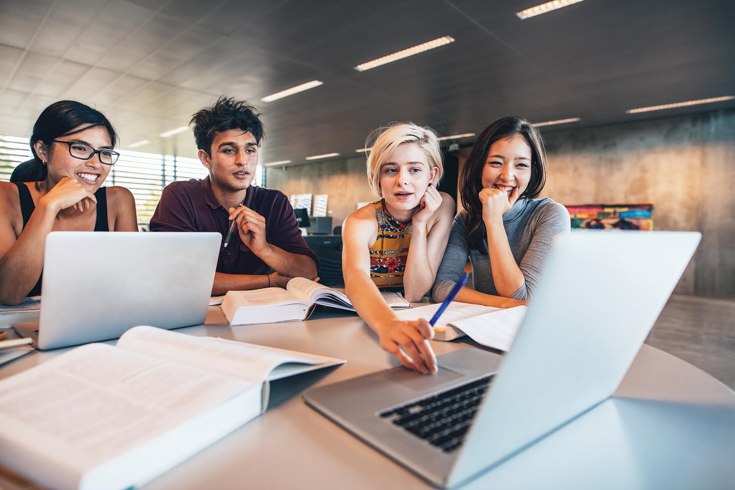 four students looking at computer