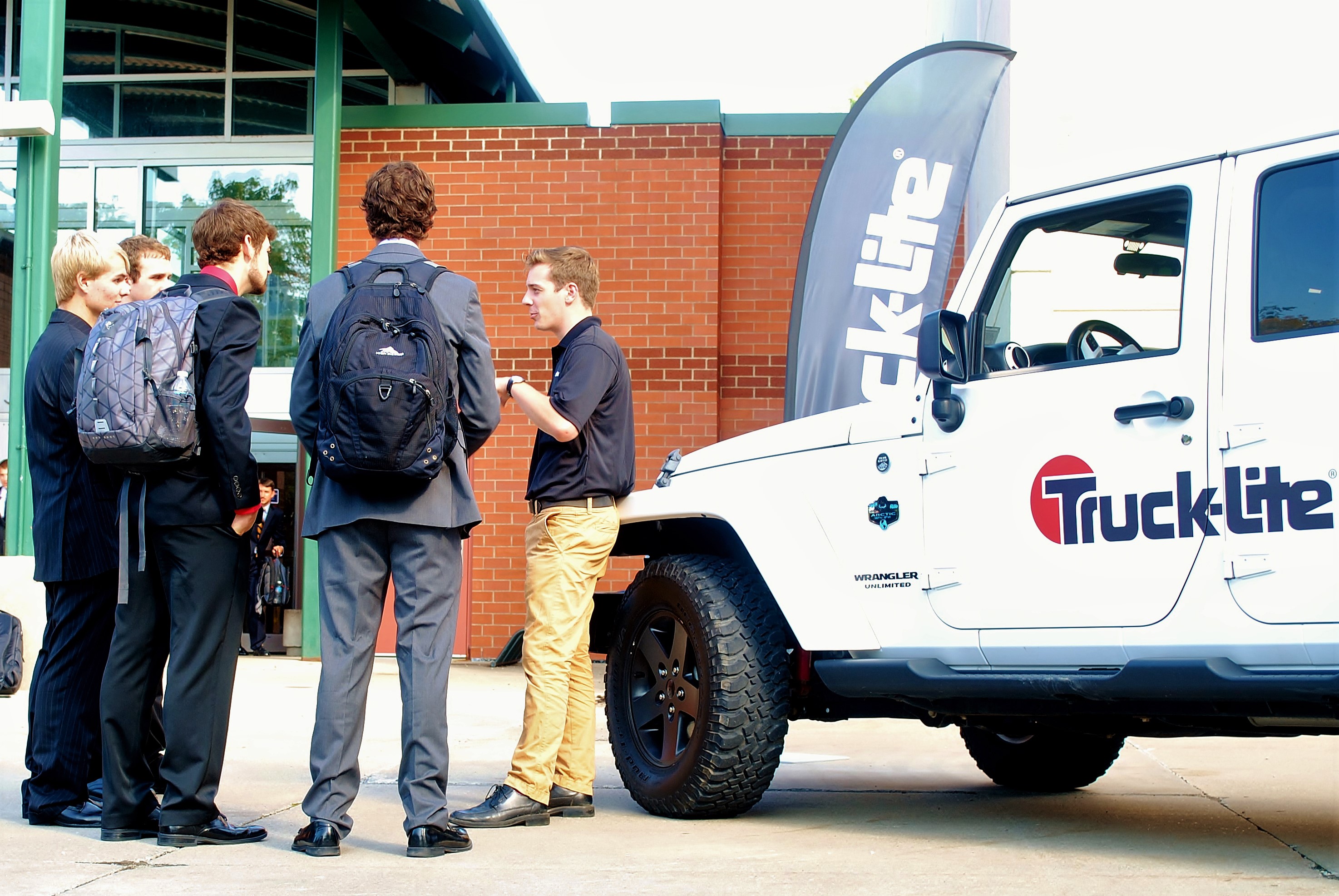 A corporate recruiter talks with several students at a Penn State Behrend career fair.