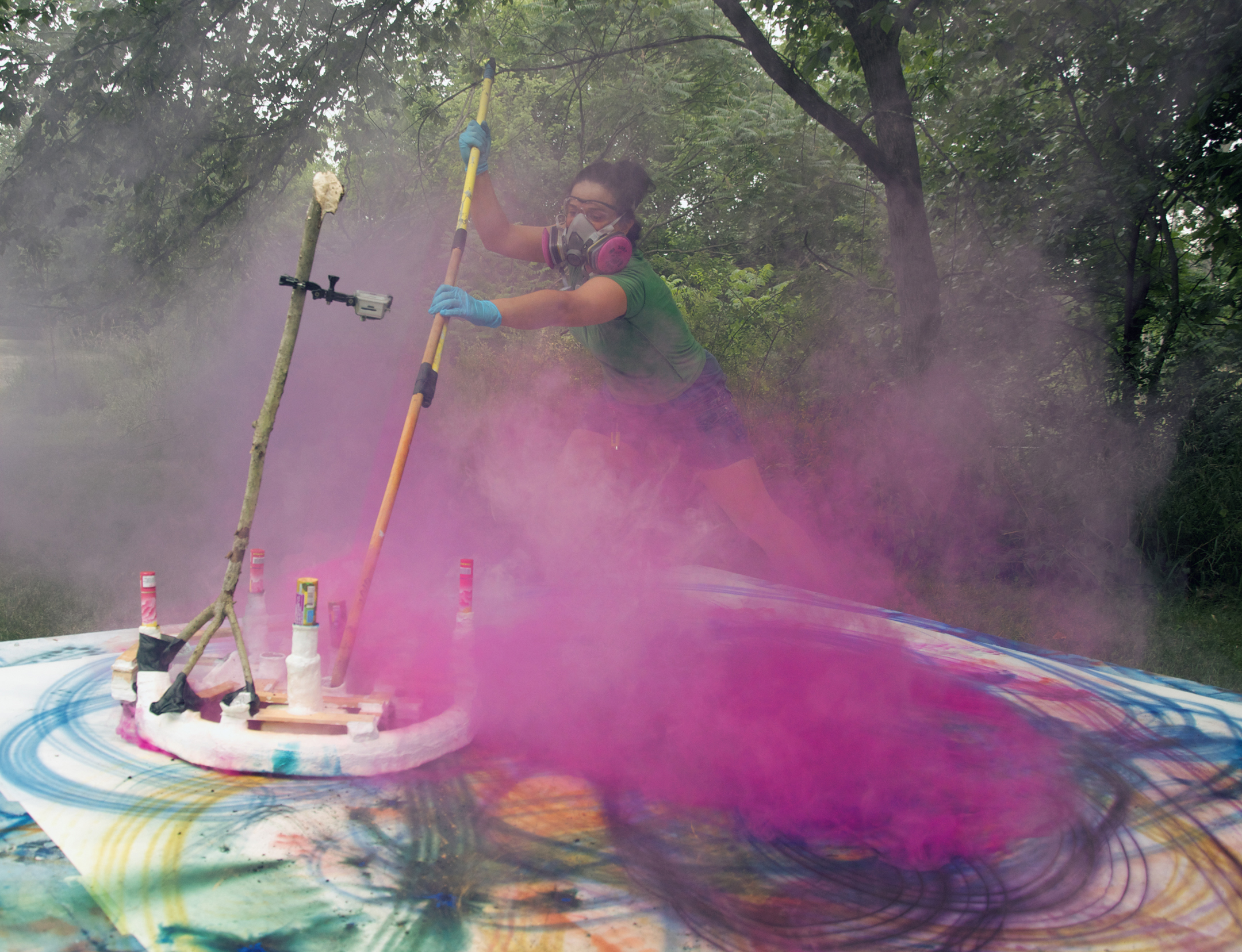 Artist paints in a cloud of pink smoke