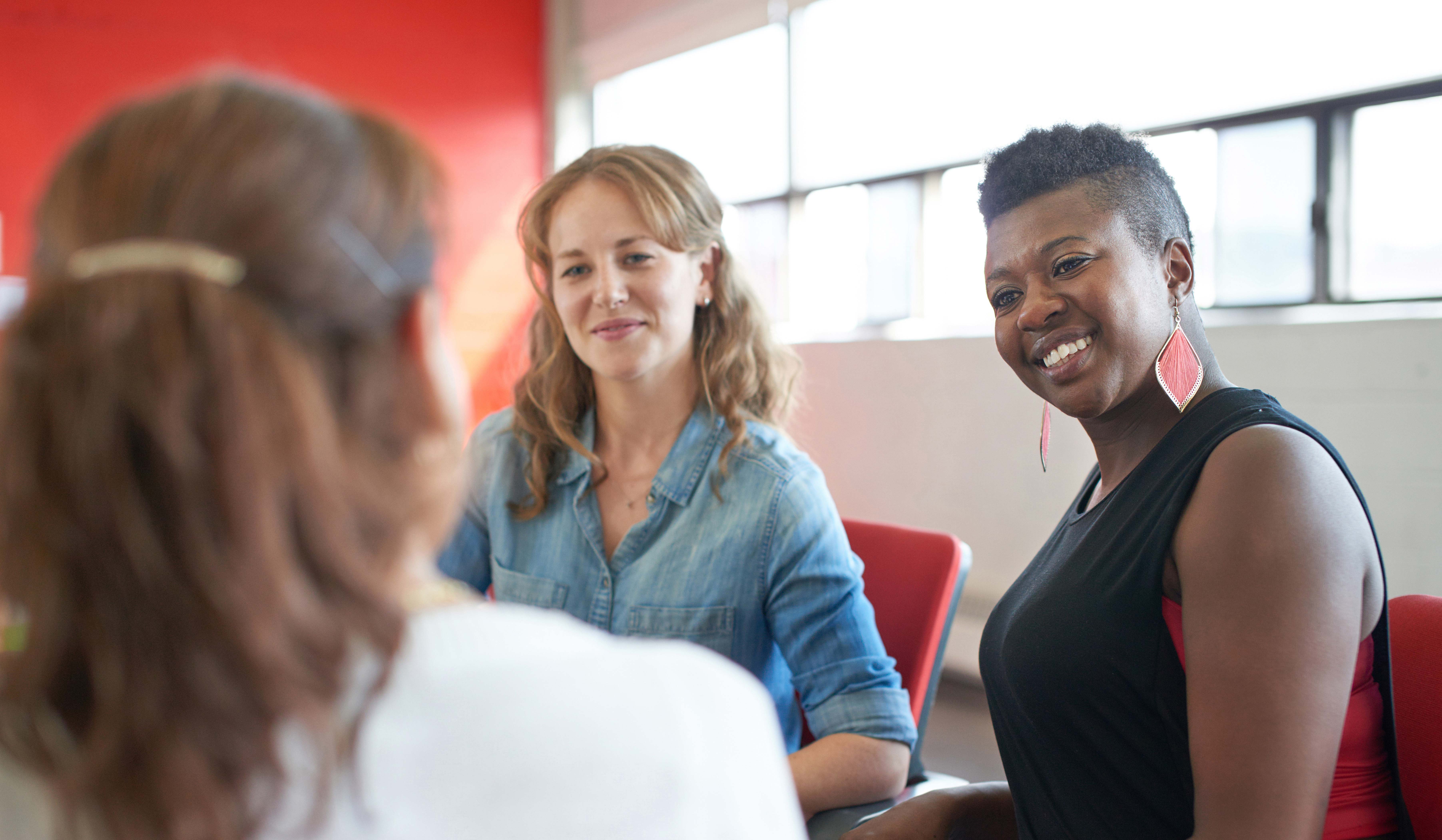 3 women talking around a table