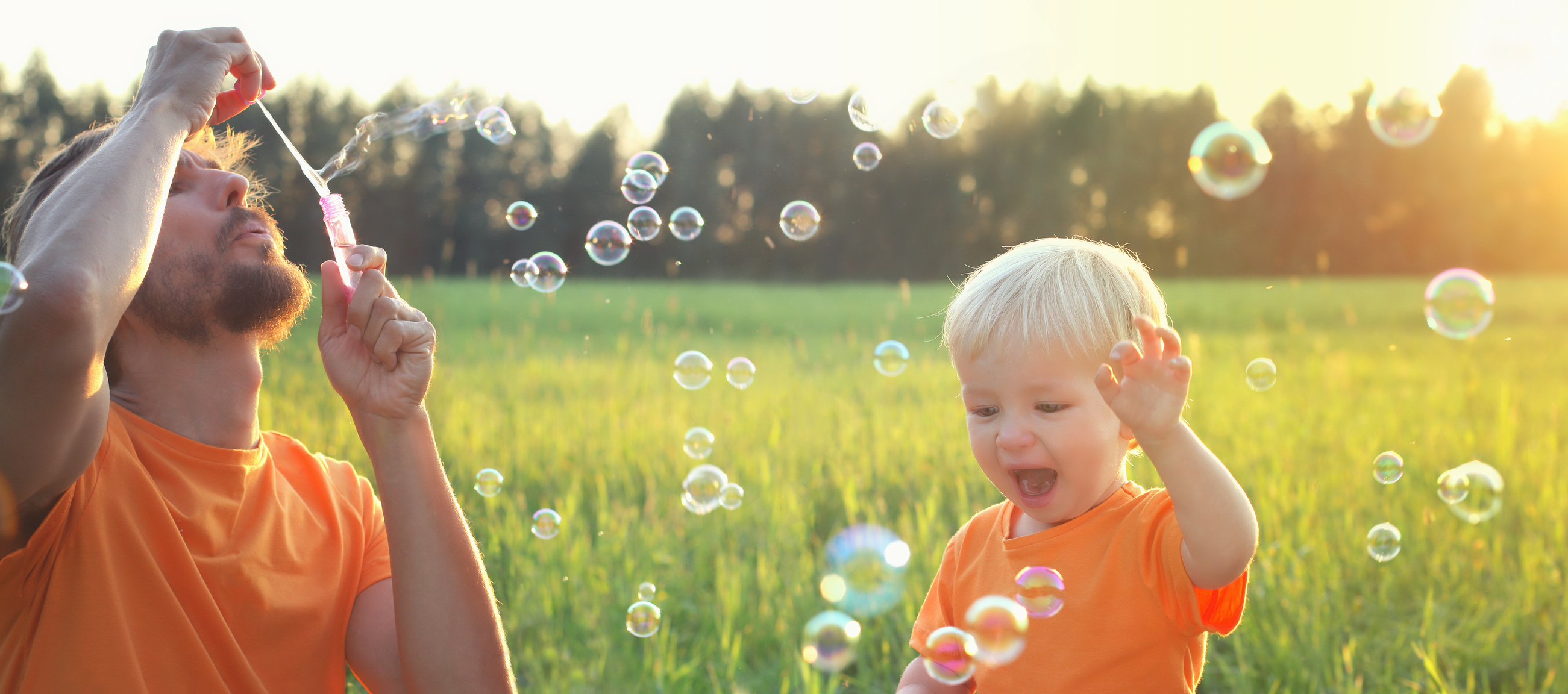 dad and toddler blowing bubbles