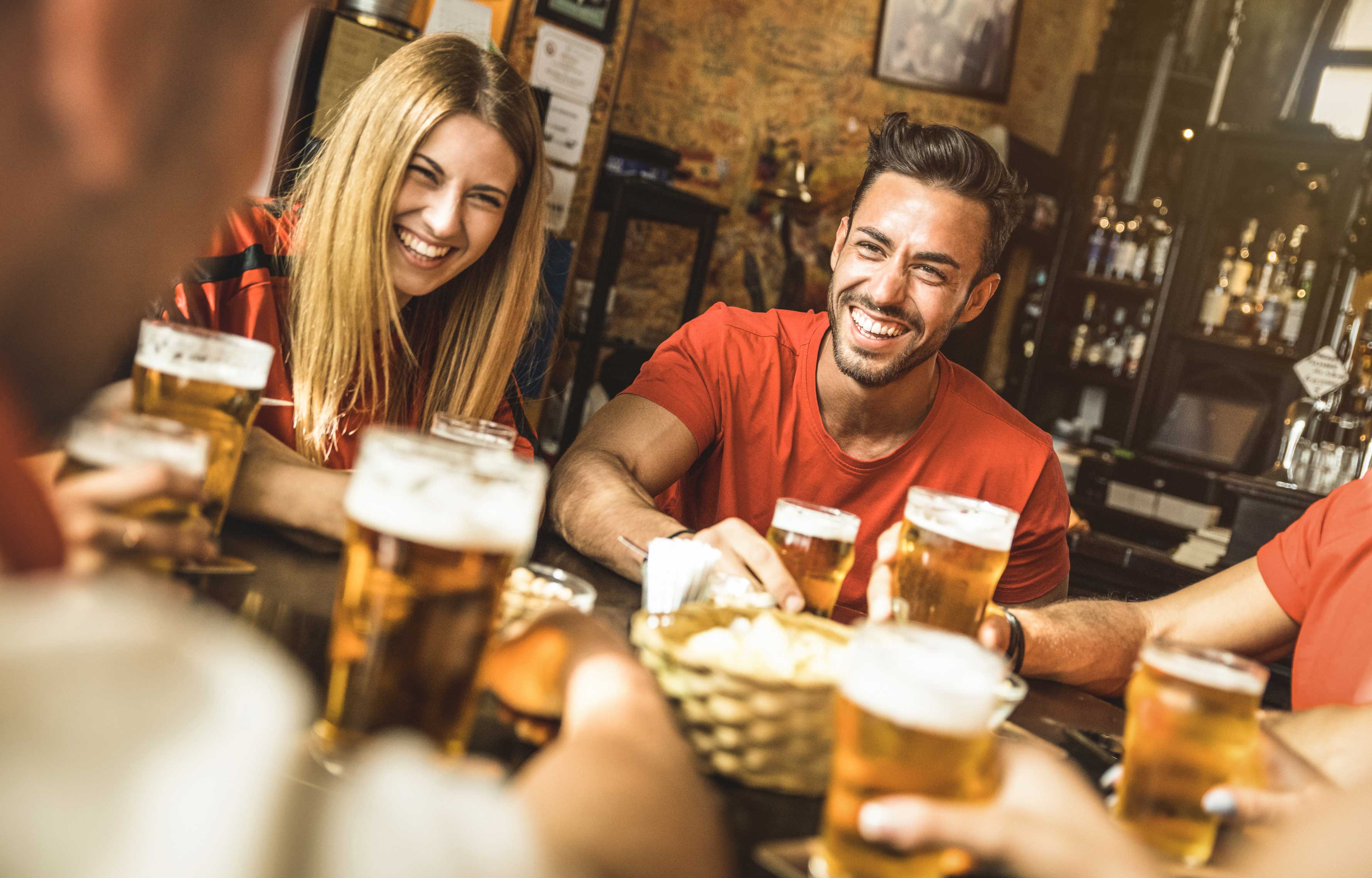 Young woman and man drinking at bar