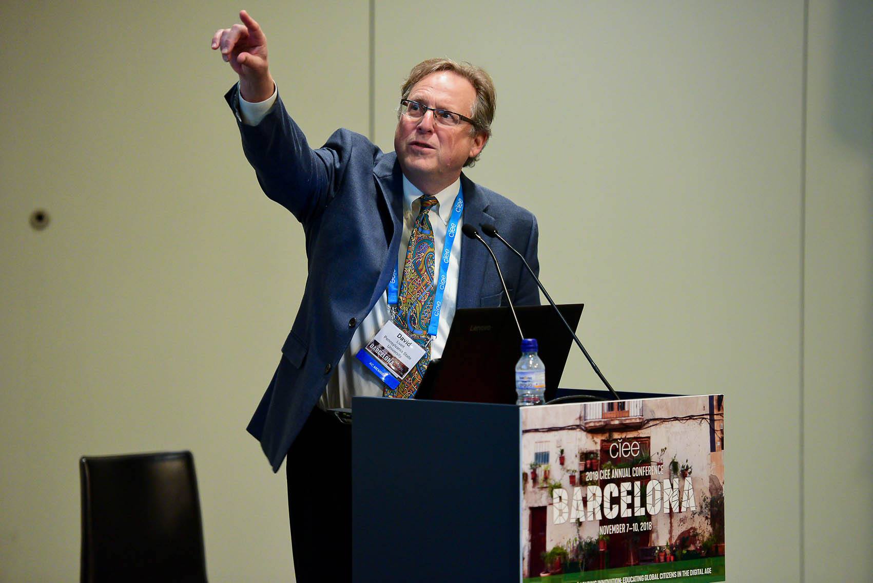 Professor Livert gesturing with his arm up during a lecture