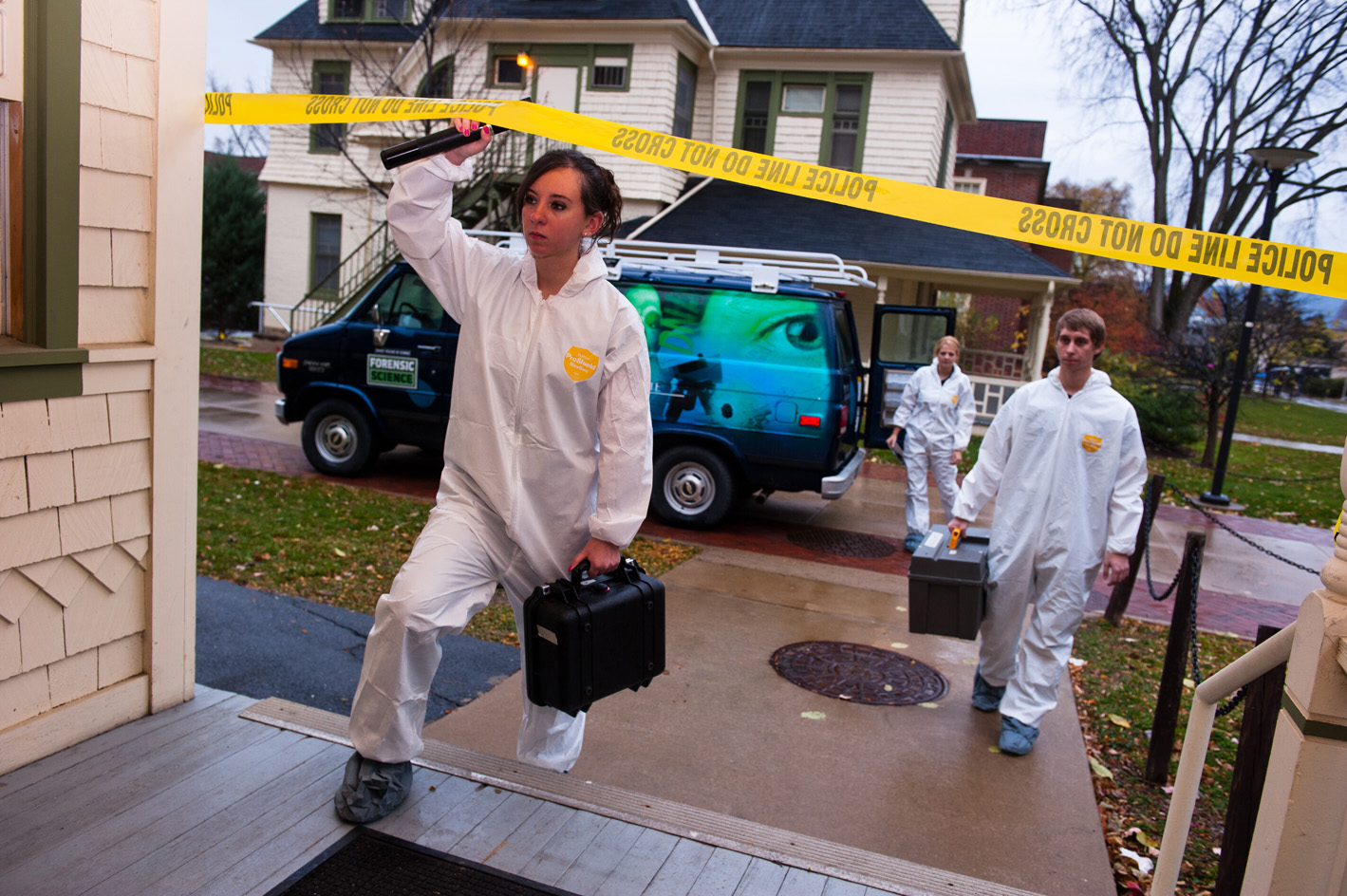 female student crossing police line at mock crime scene