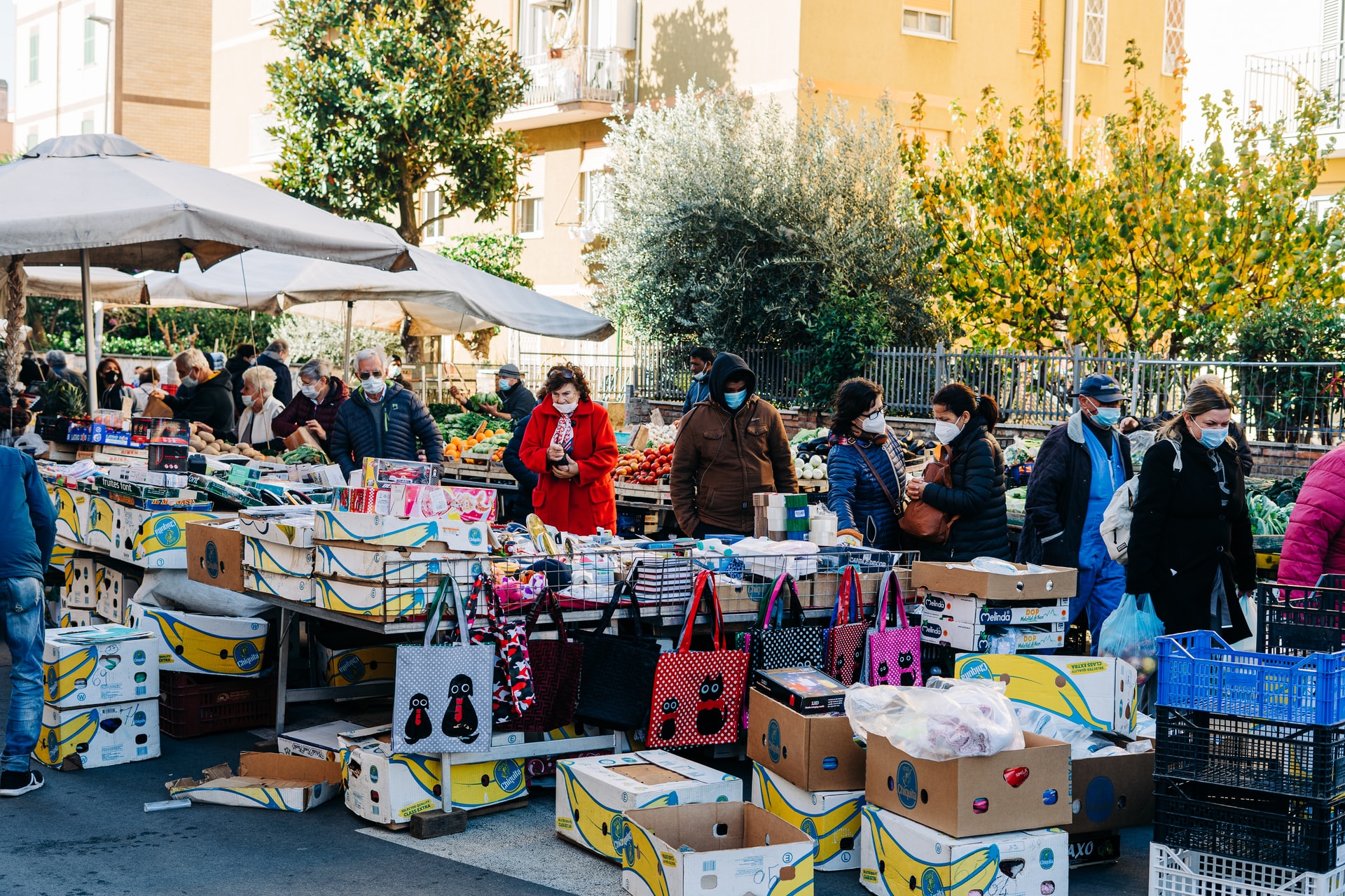 People wearing face masks shop at outdoor market