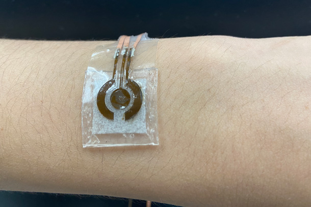 A device consisting of an electronic sensor attached to a small alkaline solution chamber is worn on a person's arm.