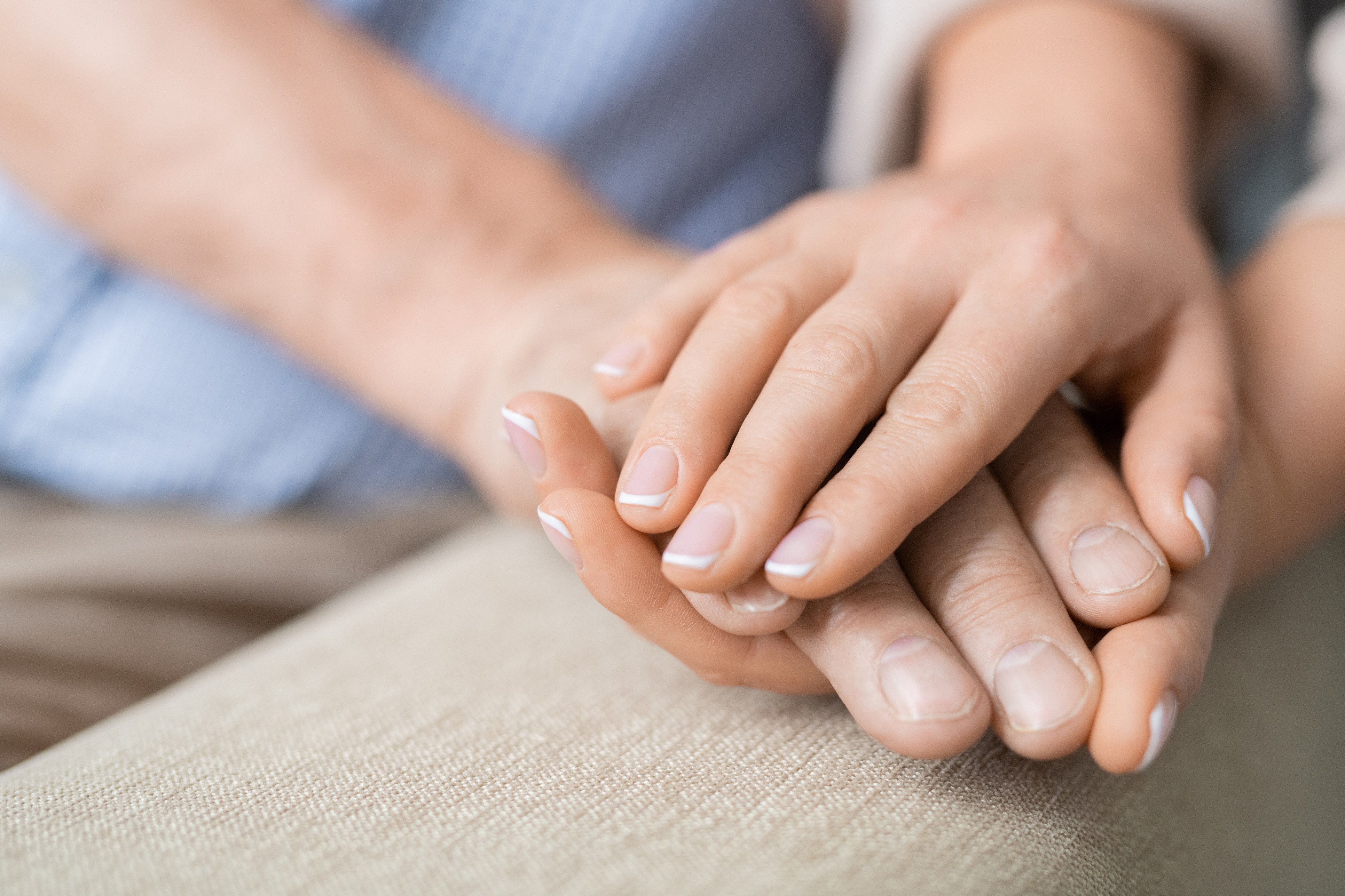 Close up of two hands holding another in support