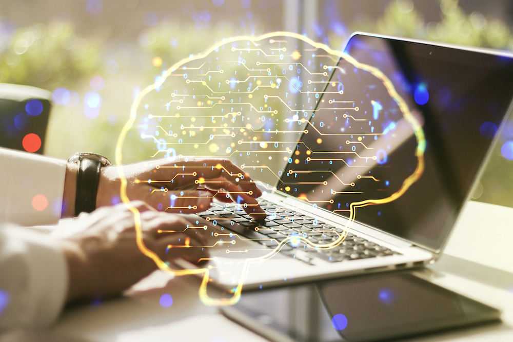 An abstract graphic of a human brain microcircuit with a hand typing on a computer keyboard.