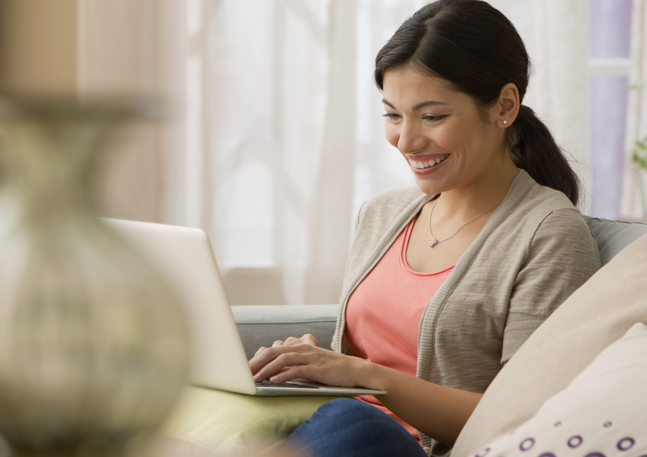 Young woman with laptop on sofa