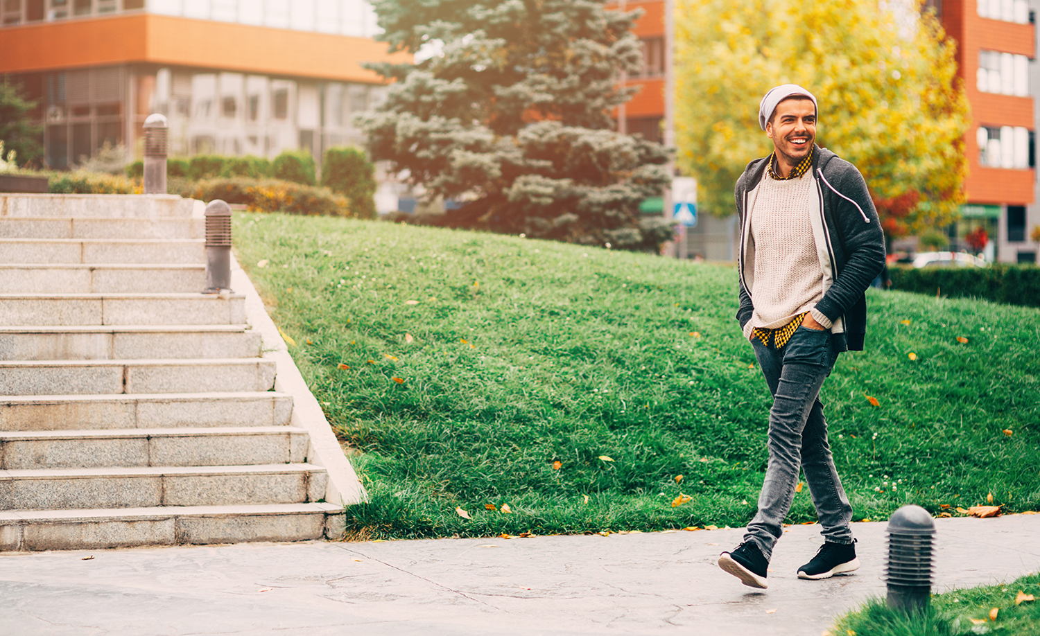 Young man walking down a sidewalk