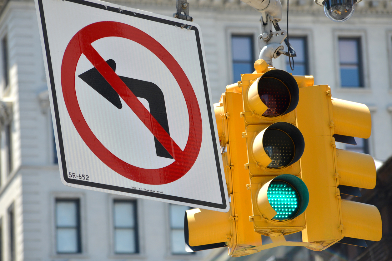 "no left turn" sign at a city intersection