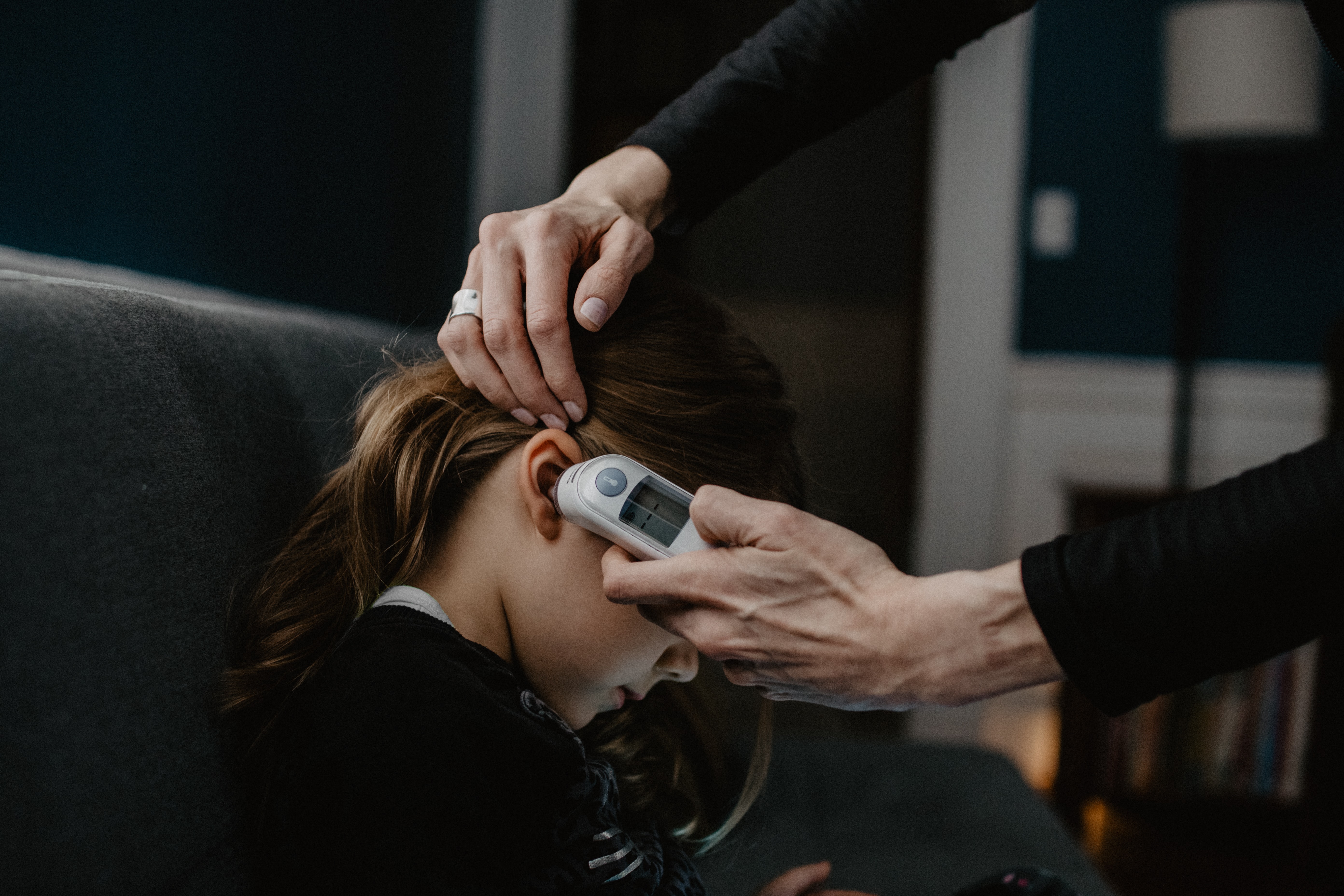 Child having temperature taken in ear.