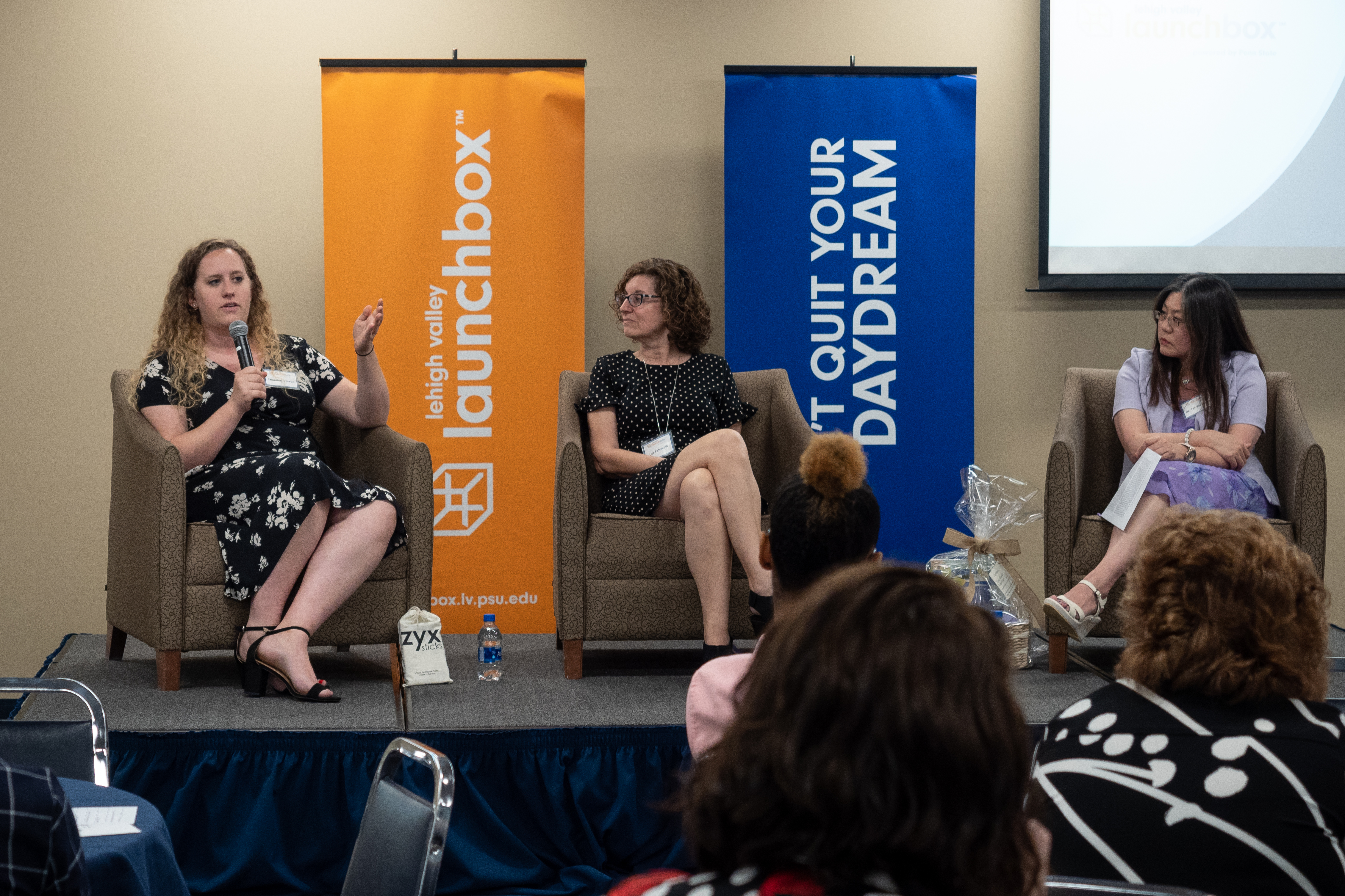 three women panelists seated on a stage