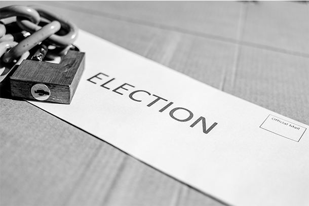 Black and white photo of an envelope stamped with the word election and a lock and linked chain of top of it.