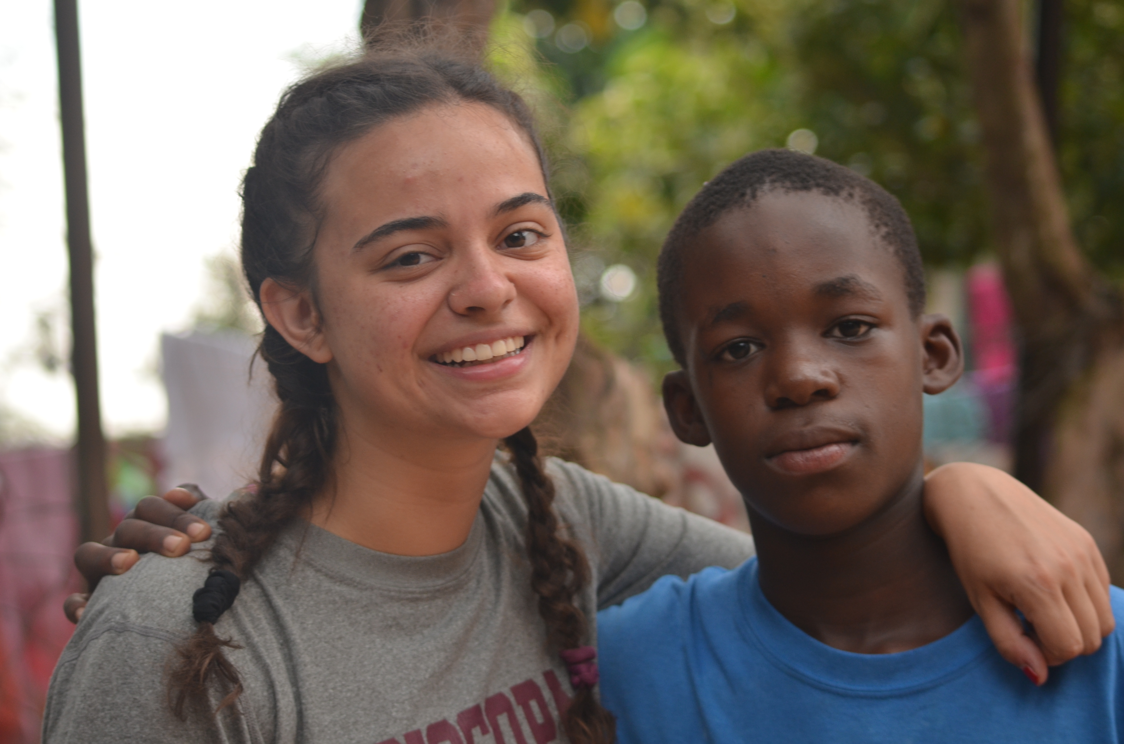 A young woman and teenage boy stand next to each other.