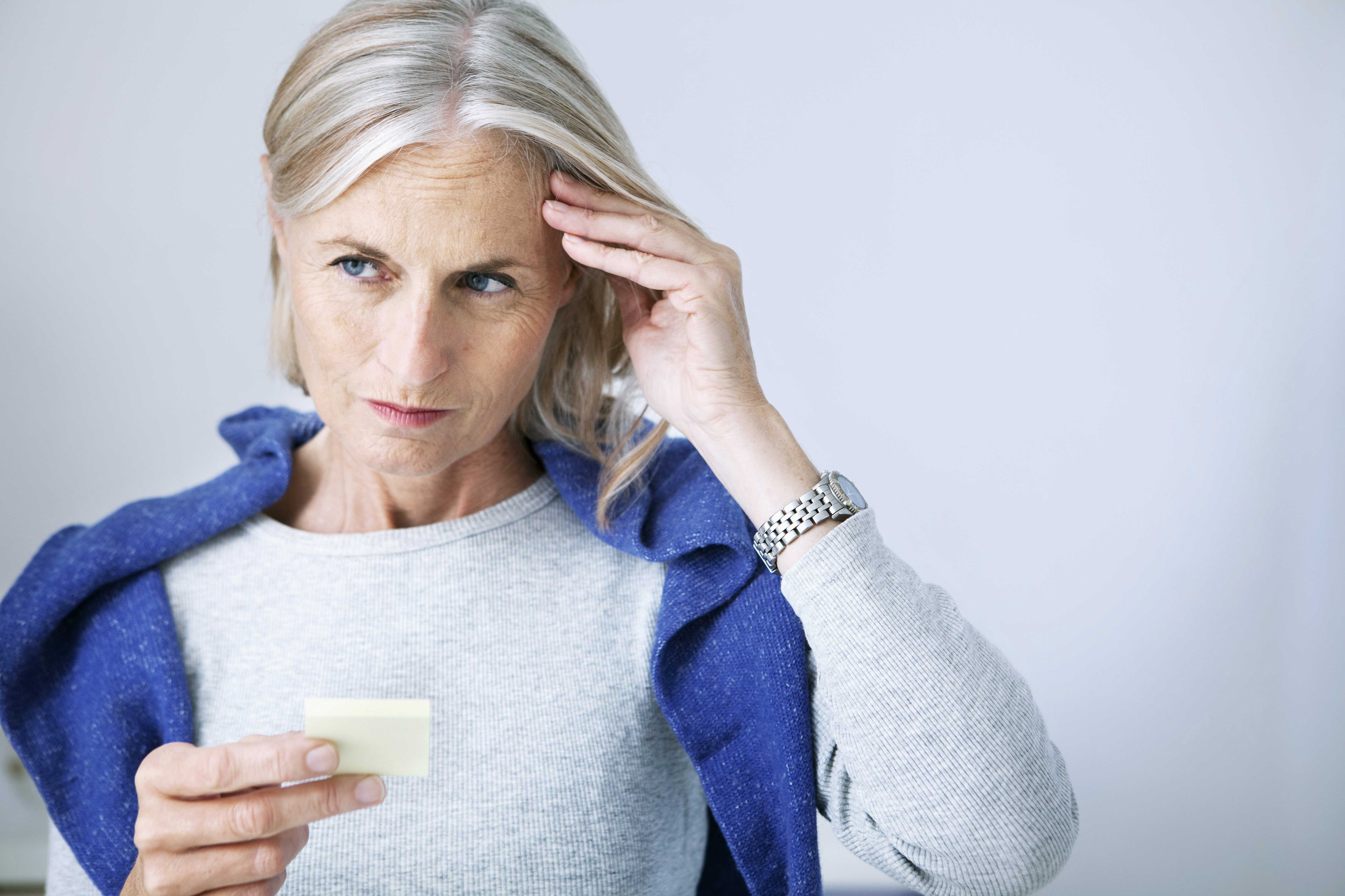 older woman with hand on forehead