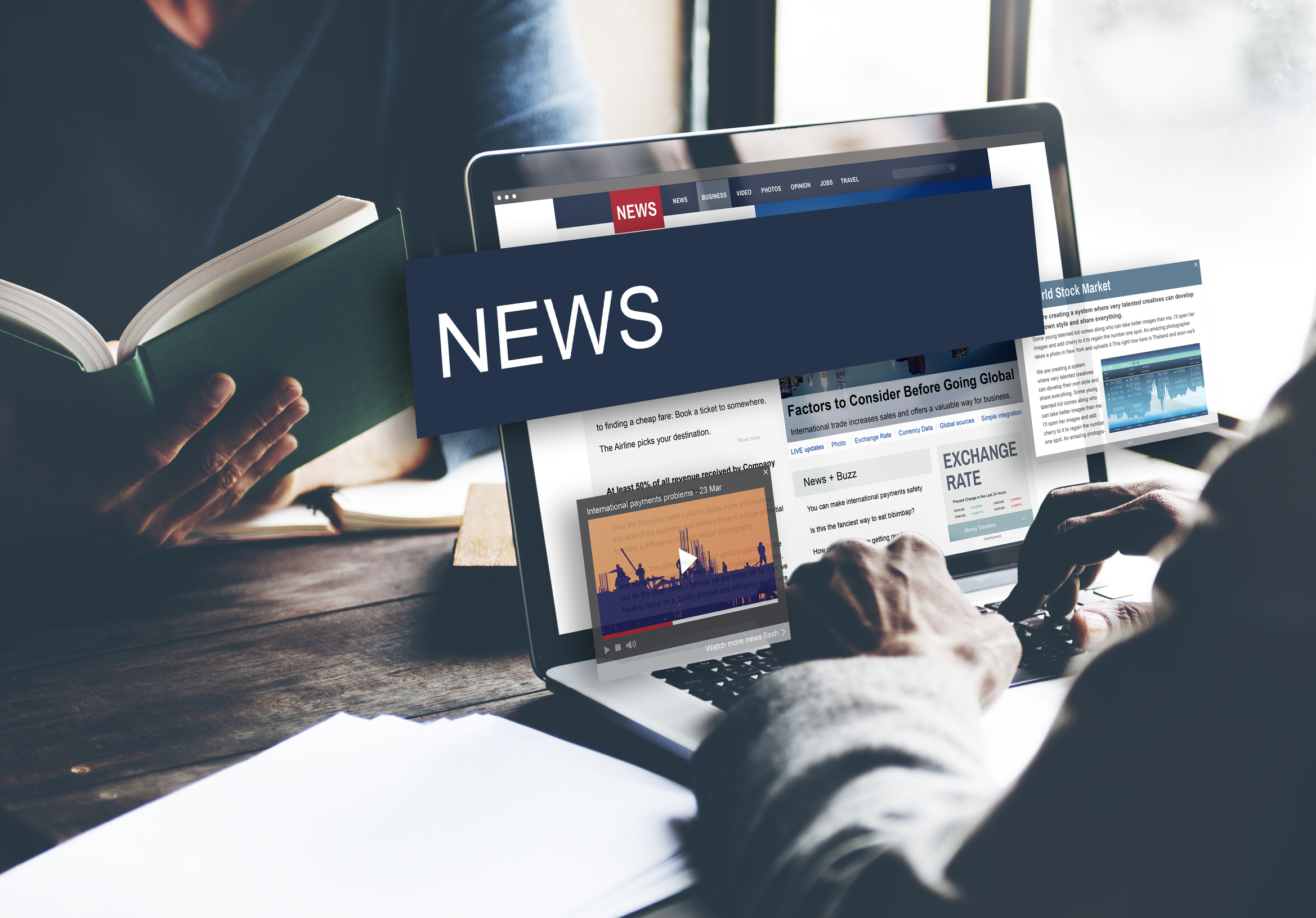 A man sits at a laptop reading the news