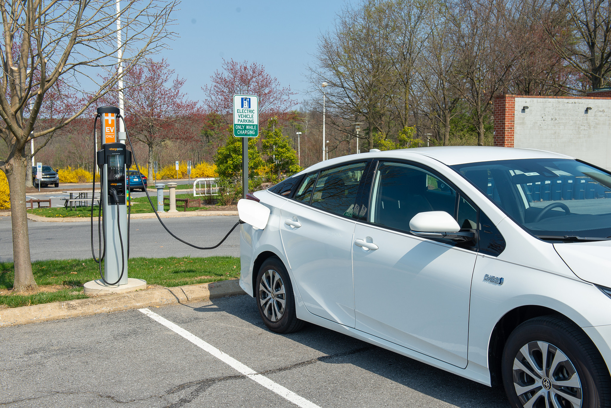 a white car plugged into an outdoor electric vehicle charging station