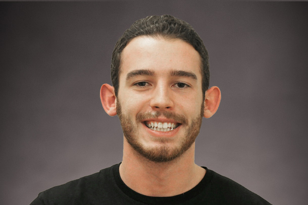 Student in black shirt smiles and poses for headshot photo