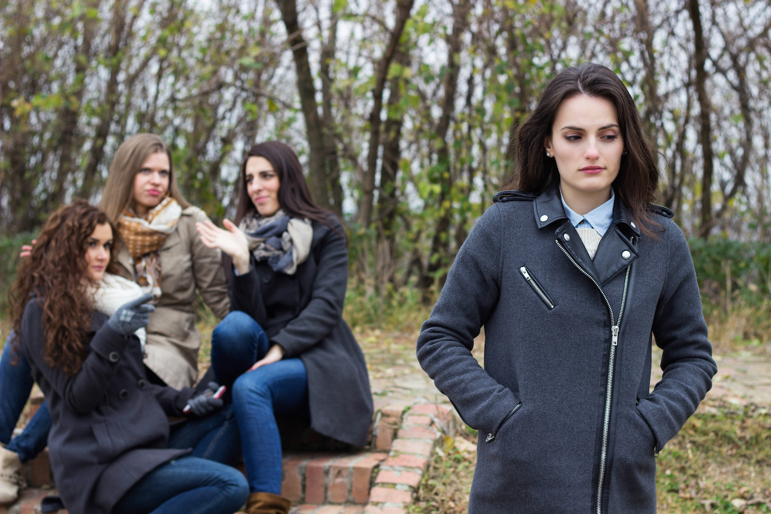 Upset girl with friends gossiping 