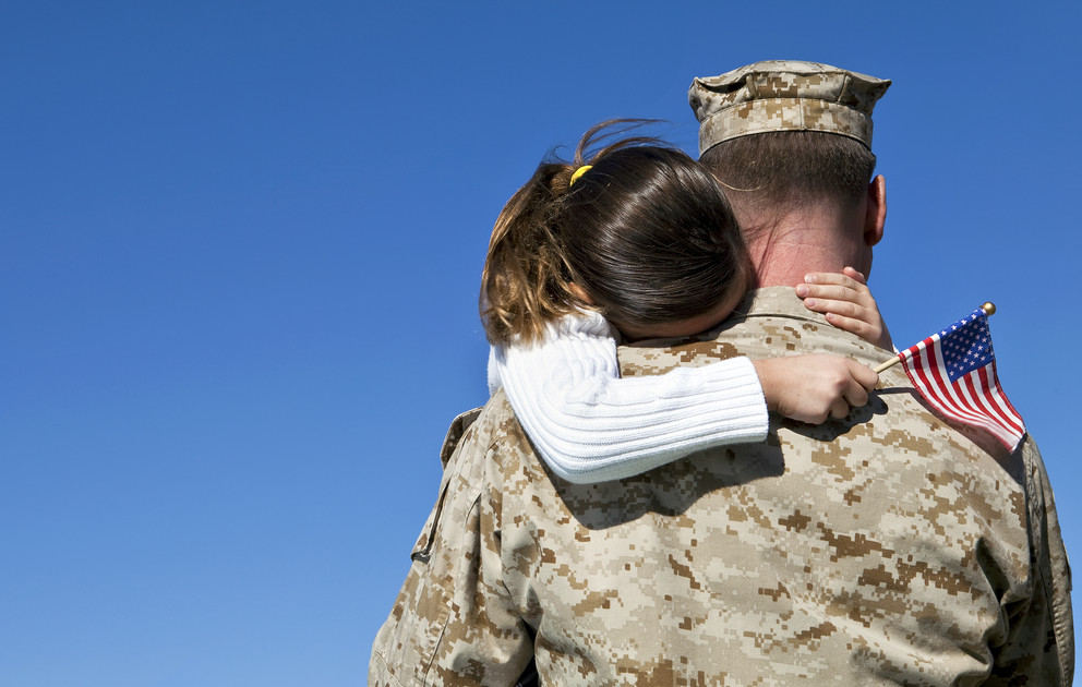 Military man hugs daughter