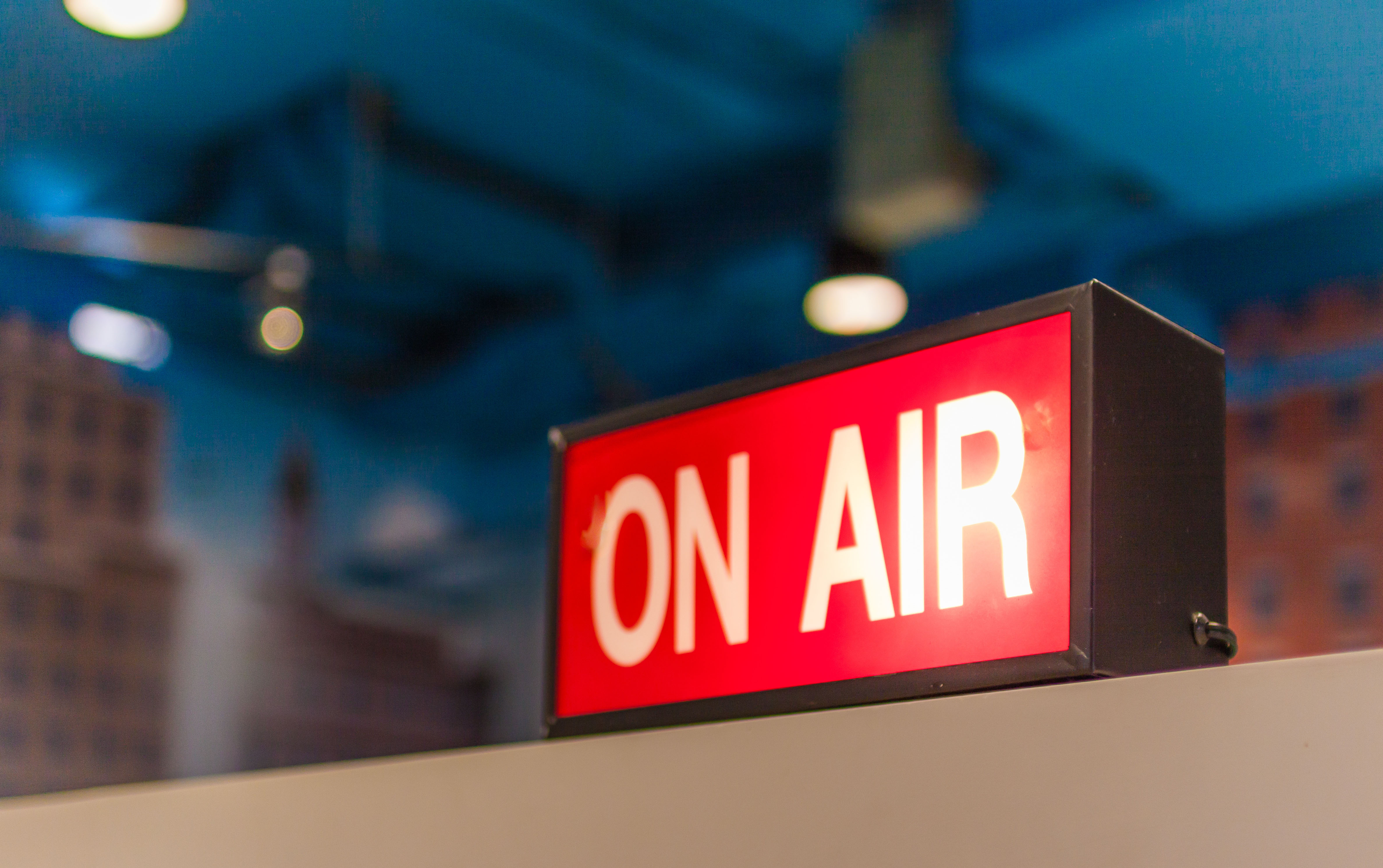 A TV studio sign with the words "on air" is lit up to indicate a live broadcast