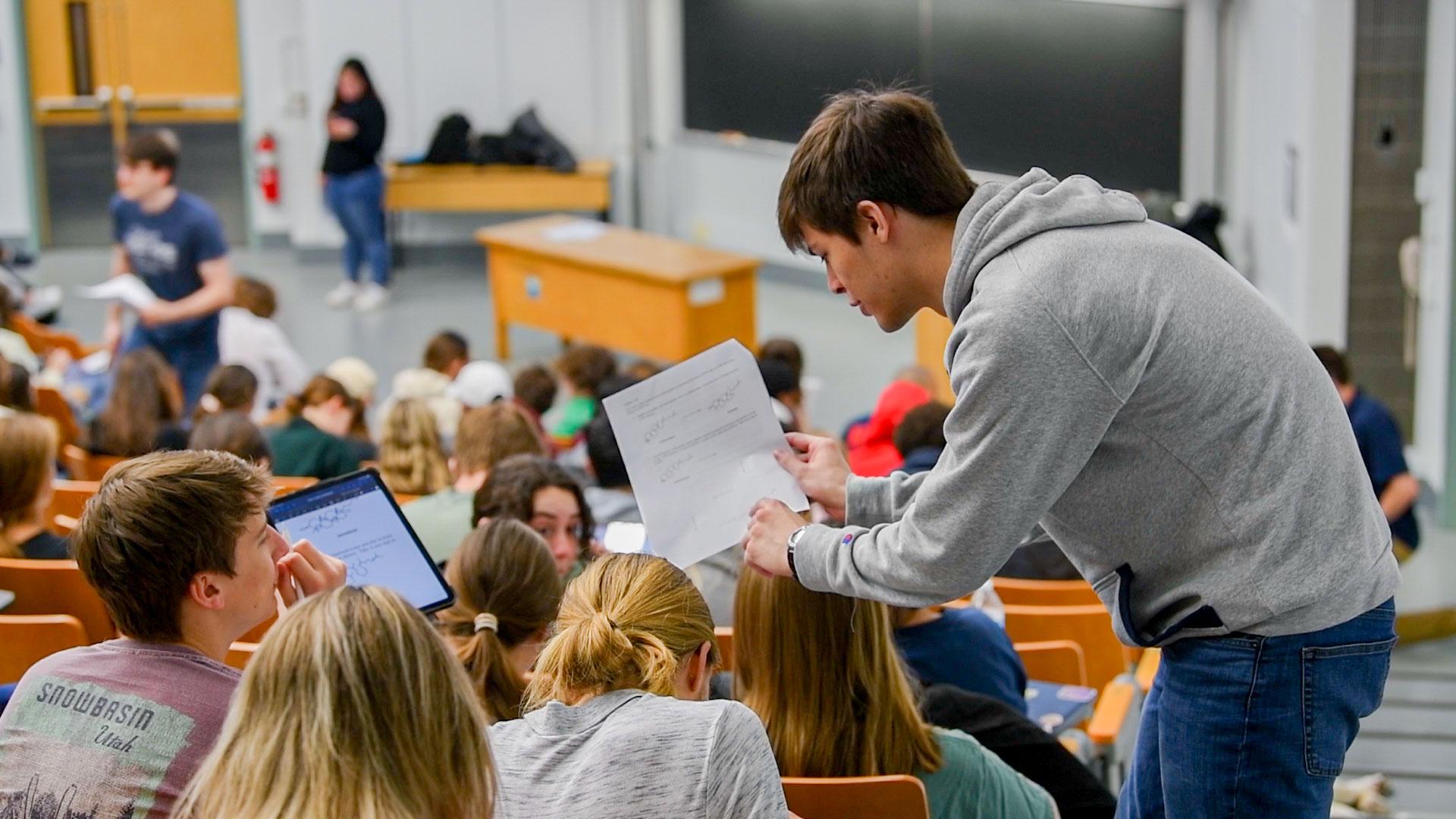 A person answers a question by a student during a lecture in a classroom.