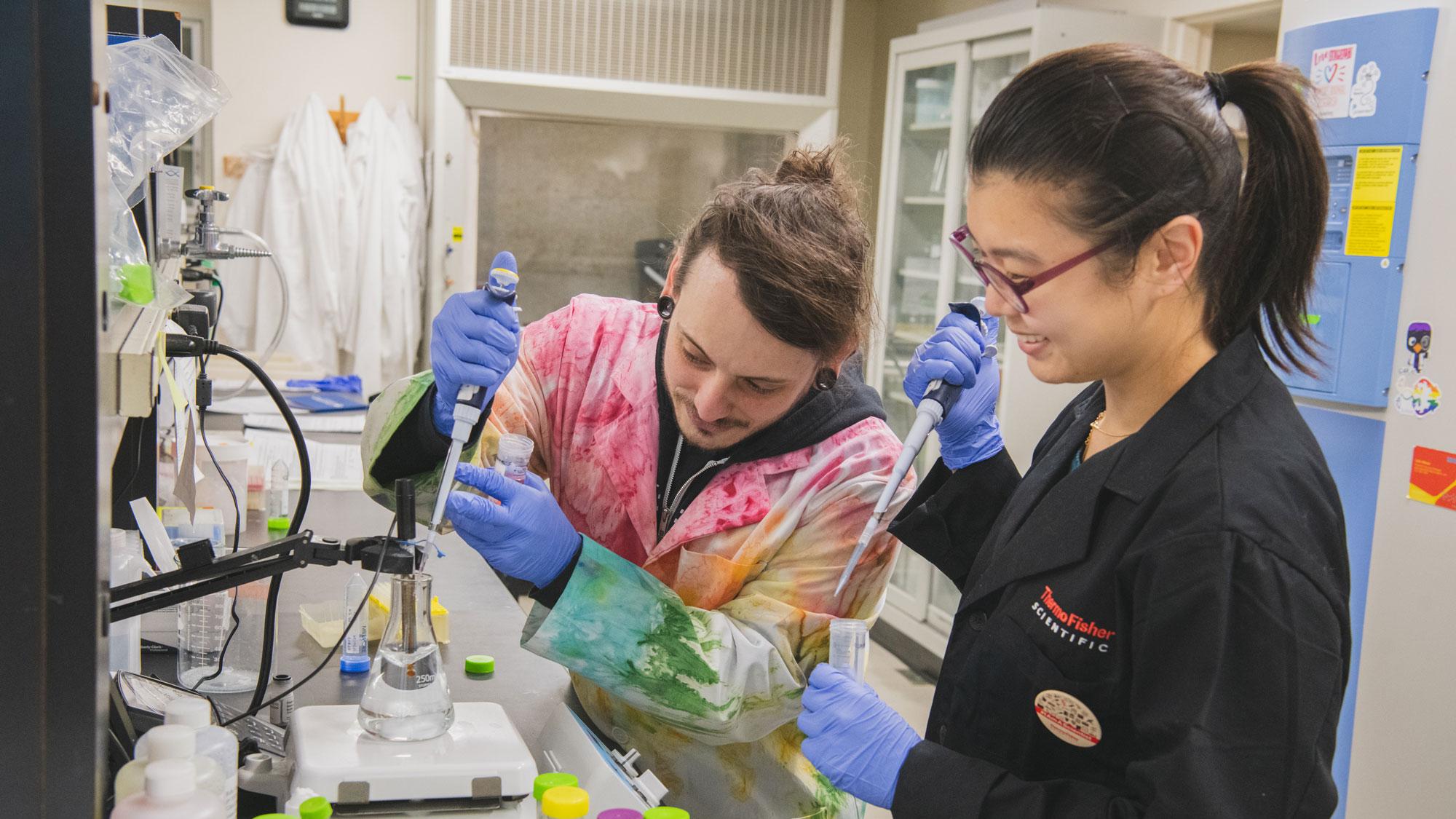 Chad Smies and Jiyeon Baek use pipettes in the lab