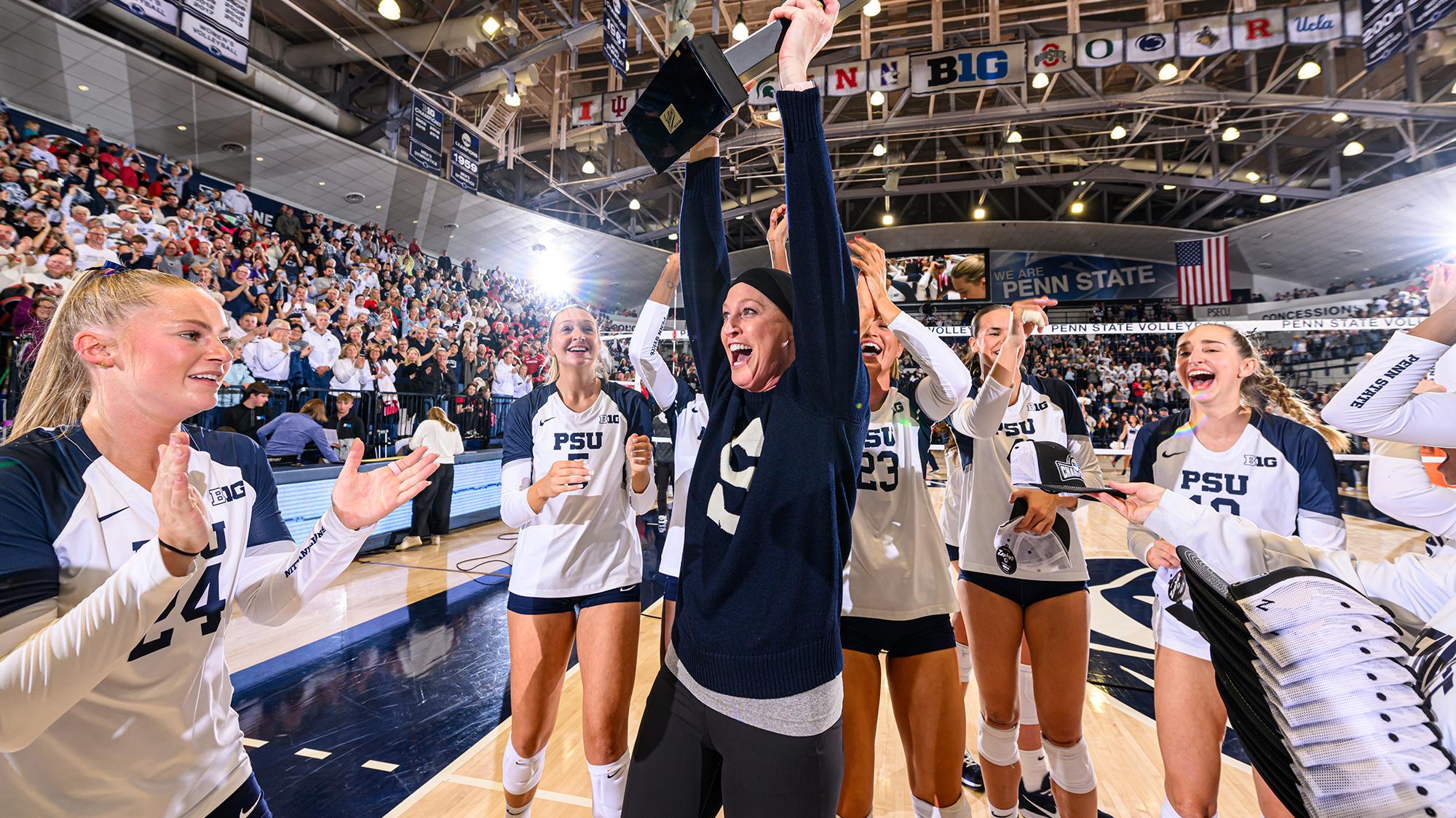 Schumacher-Cawley celebrates by raising trophy with her team