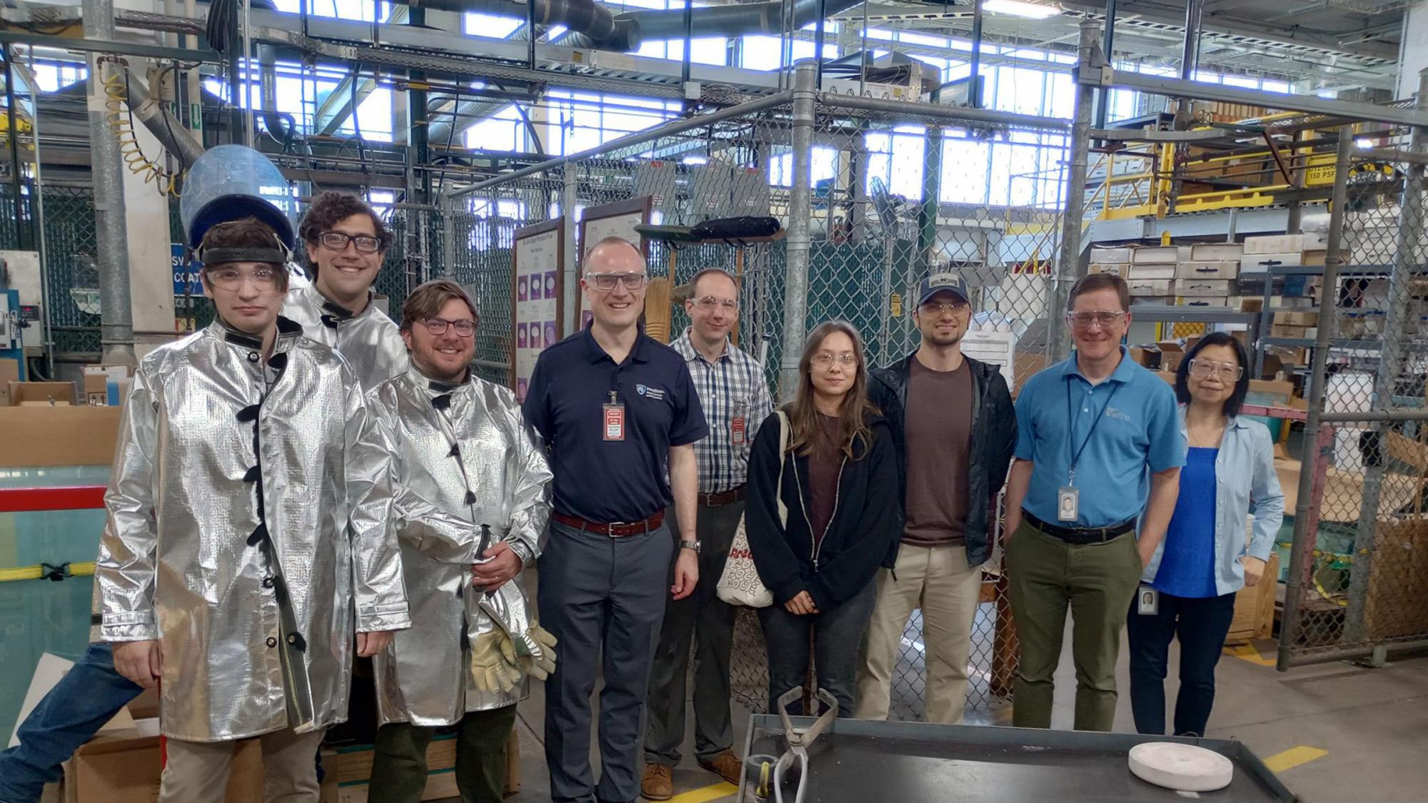 A group of people in a glass-making factory