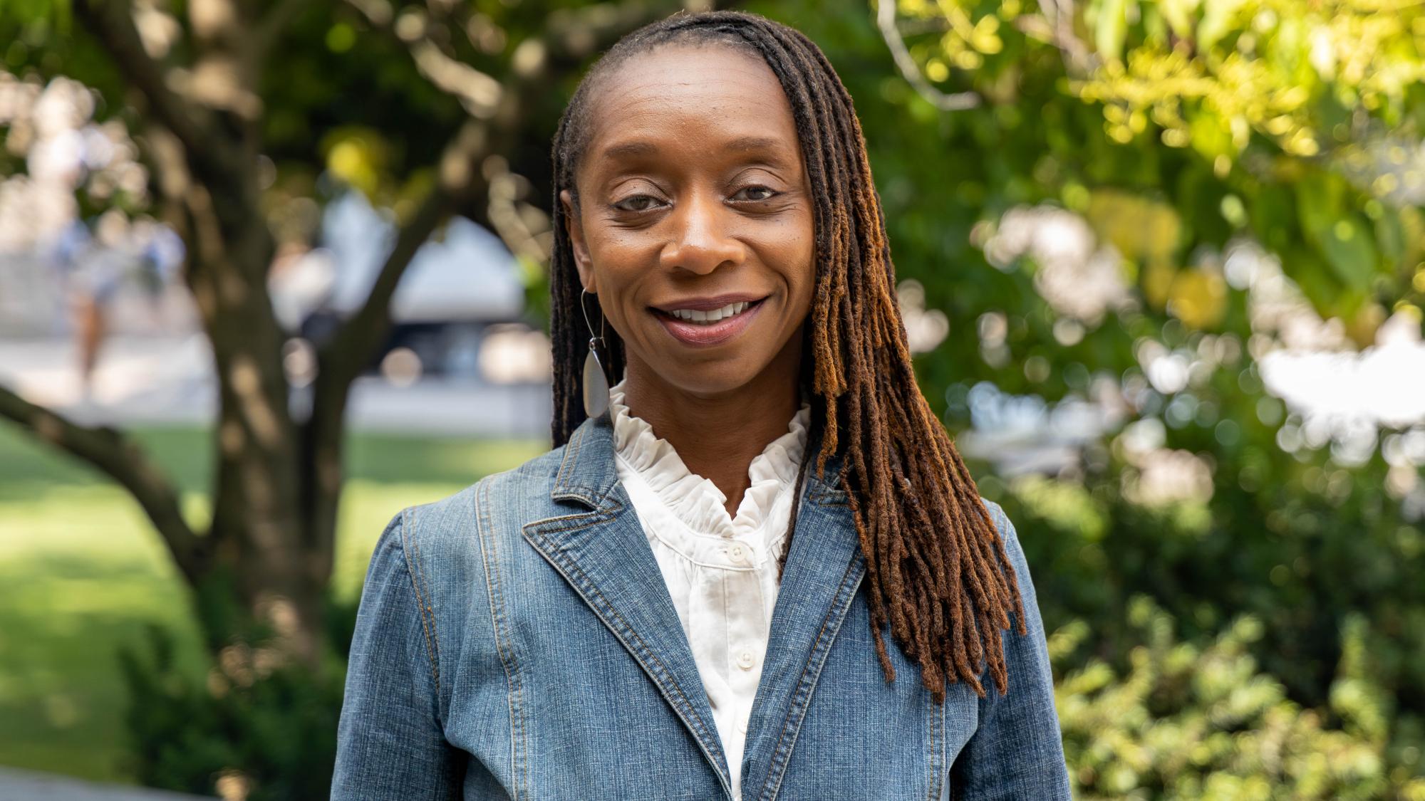Sherita Johnson wears a blue jacket and white blouse while standing on Penn State's campus. 