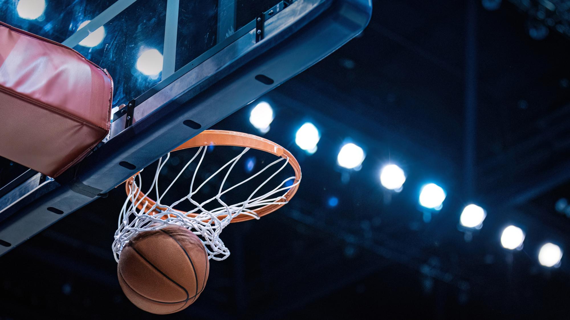 A basketball going through a hoop and net.