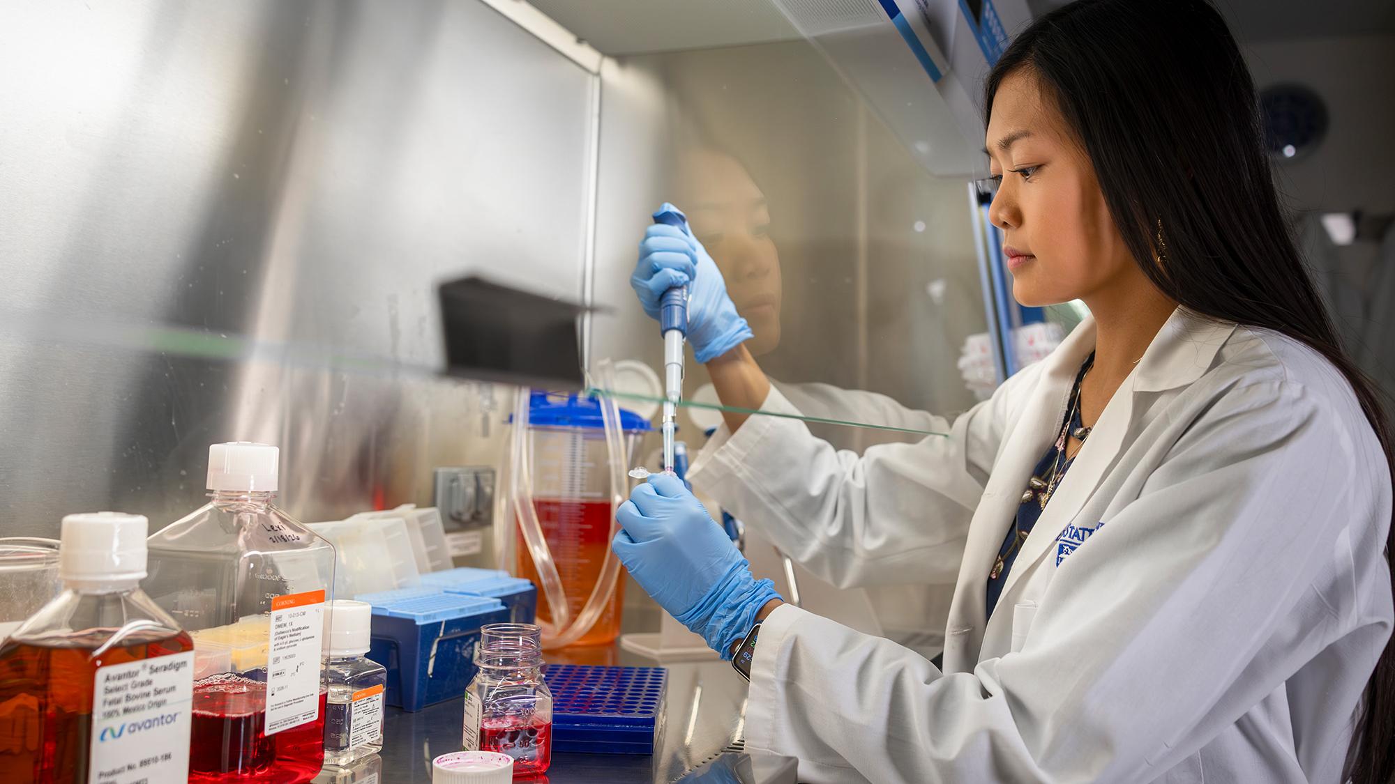 woman using pipet in lab