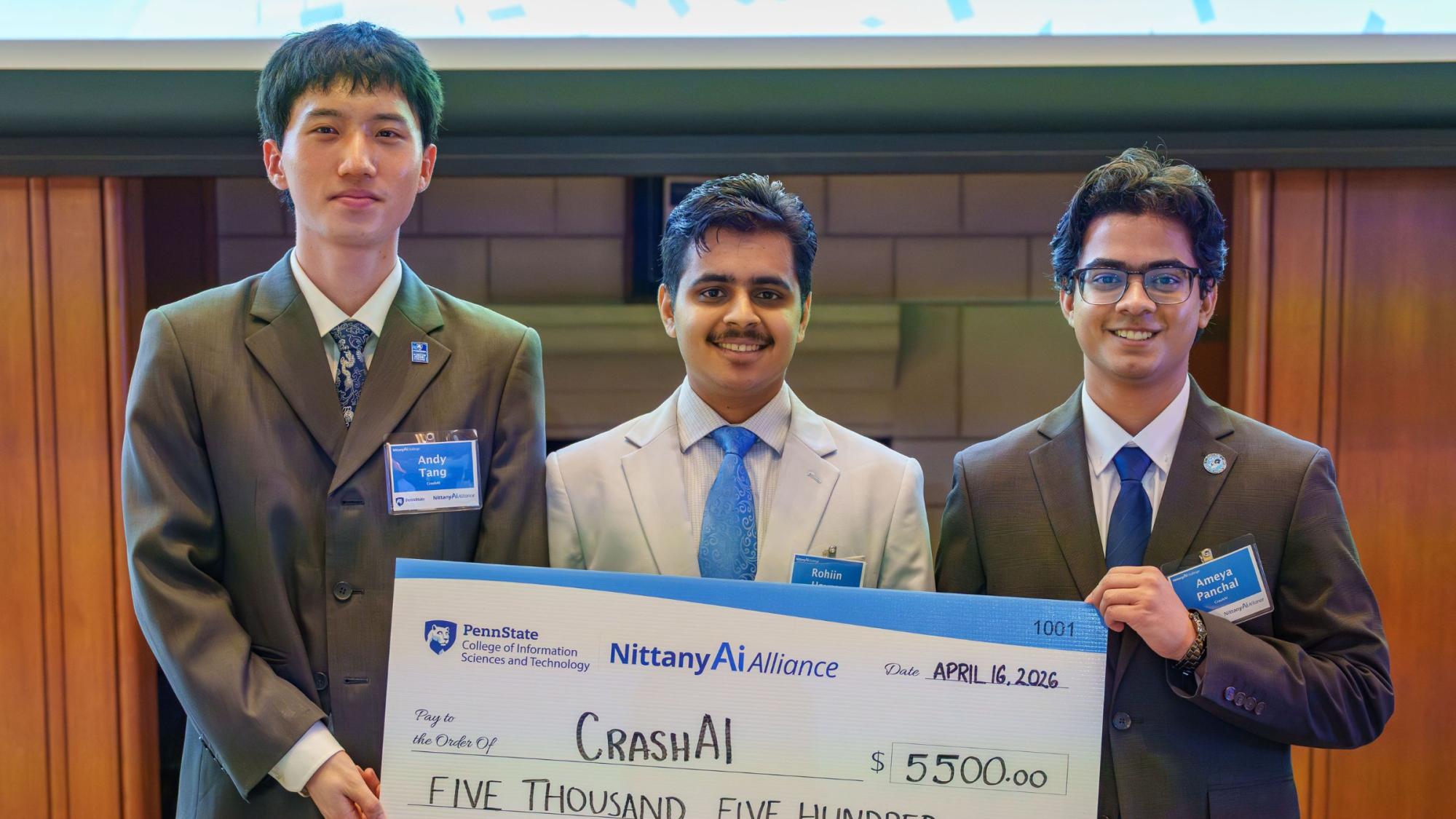 three college students in suits hold giant check