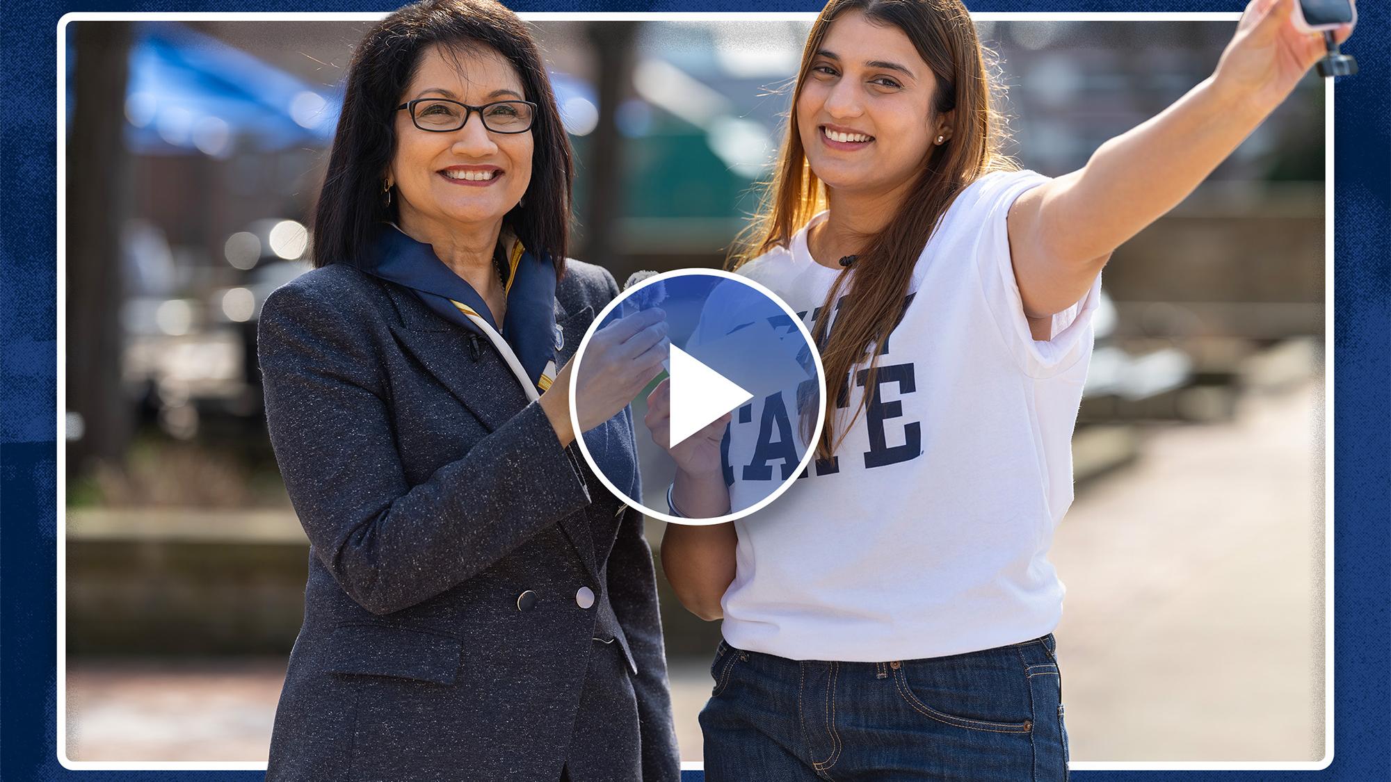 Neeli Bendapudi (left) and student Kavishi Halwavala stand together and Neeli is holding a mic and Kavishi is holding a cell phone.