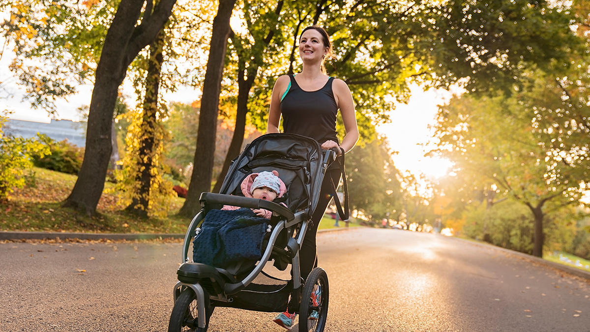 Woman running pushing child in jogging stroller