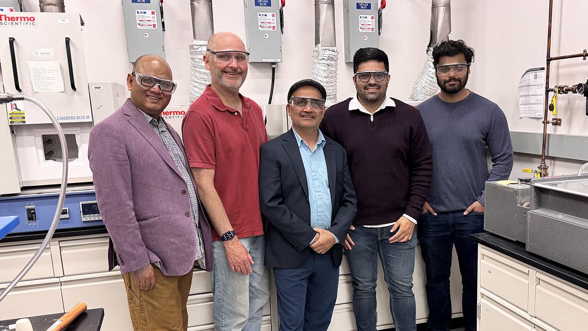 Five individuals pose in a lab 