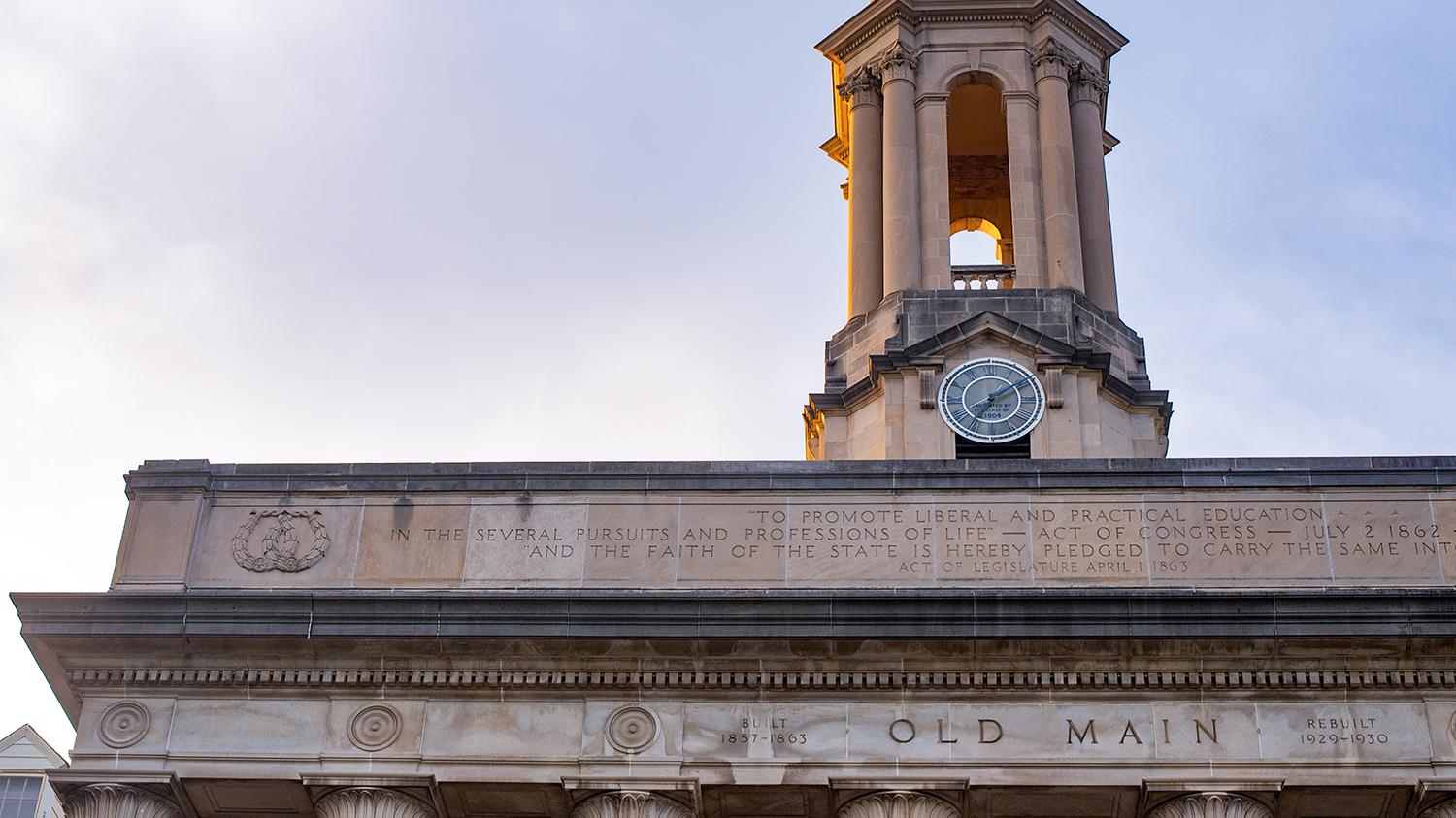 An image of Old Main's bell tower and the words Old Main engraved in stone