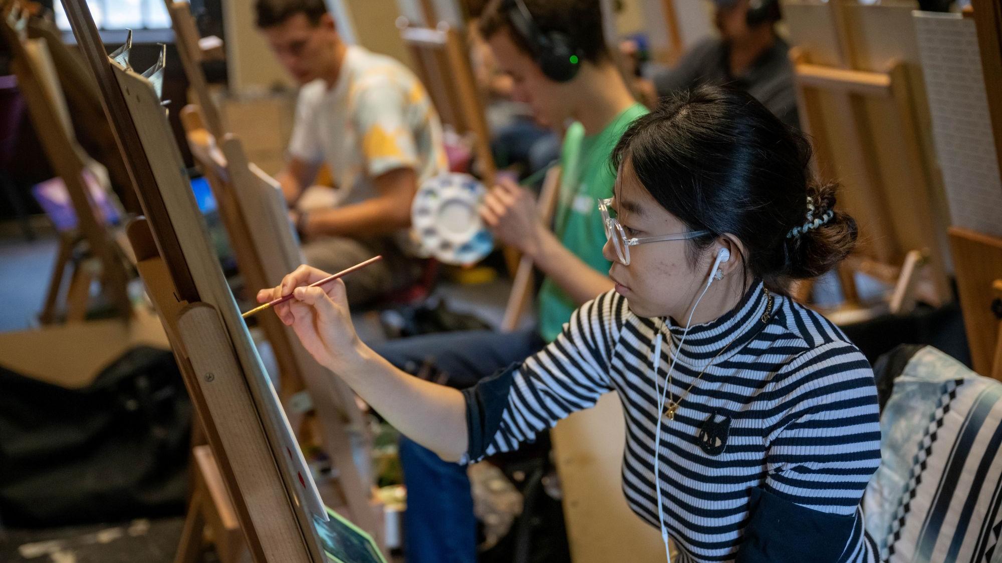 A student paints in an art class at Penn State Behrend