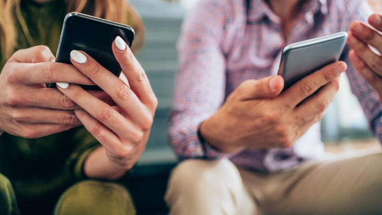 Two people holding smart phones