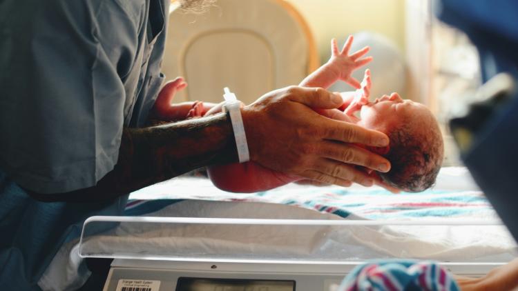 Person holds a newborn