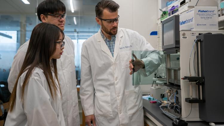 Researchers in lab coats standing in a lab