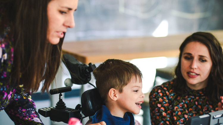 Two instructors working with a child with cerebral palsy