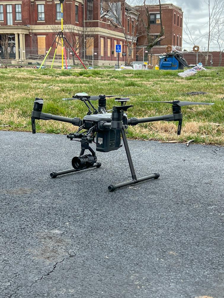 A black drone on pavement