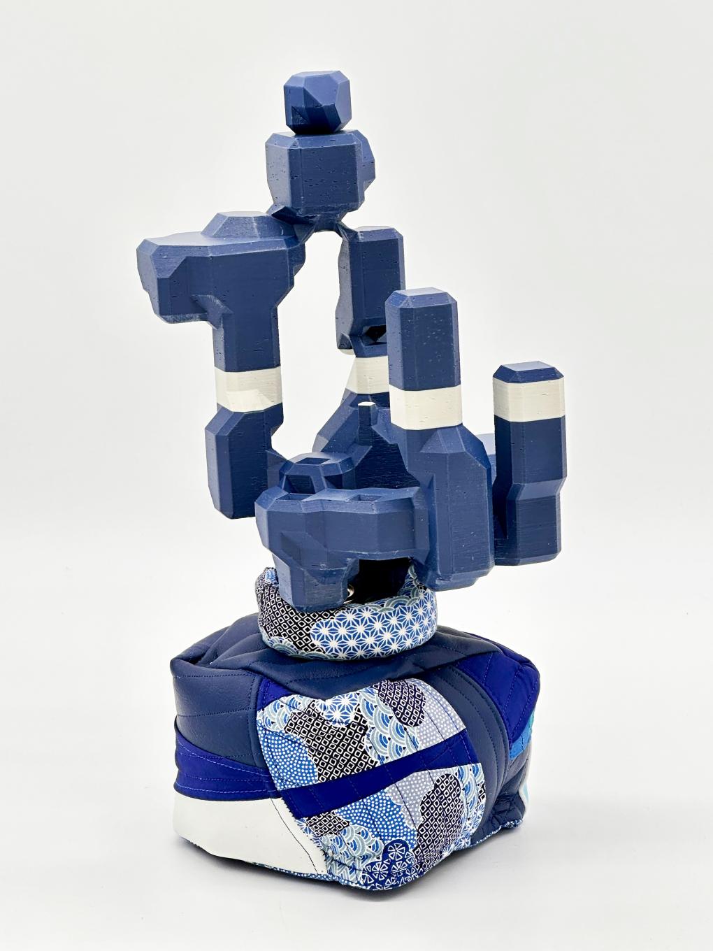 A blue and white 3D-printed sculpture in a fabric base casing.