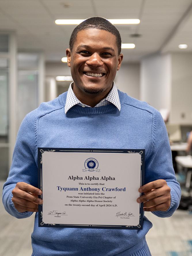 Tyquann Anthony Crawford stands with his Tri-Alpha induction certificate
