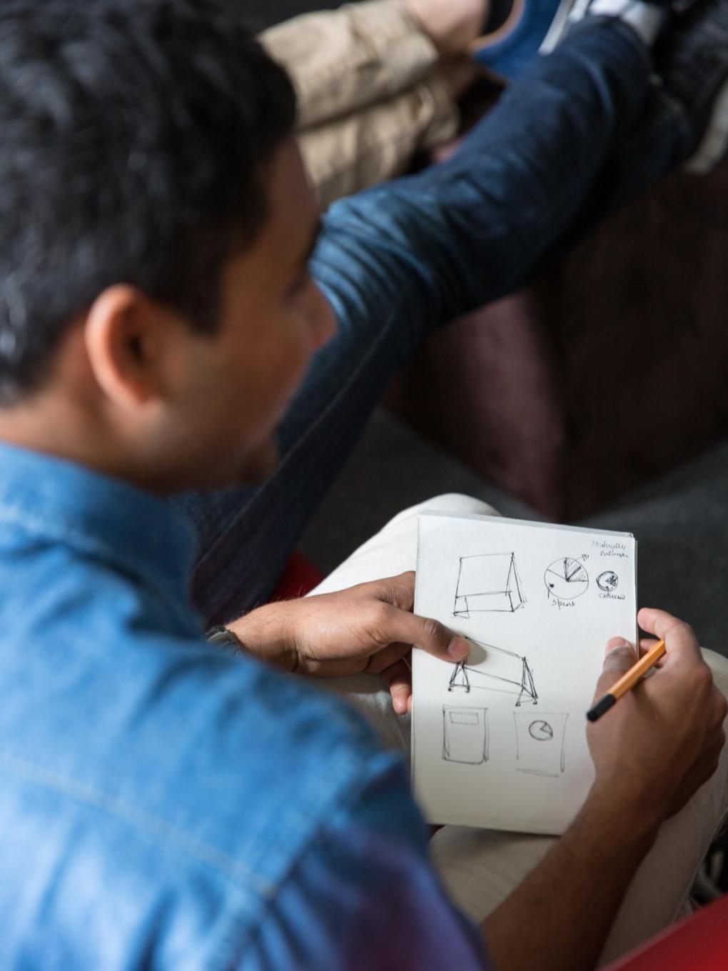 Rohan Prabhu, engineering design graduate student, sketches out ideas and concepts for his team's financial service prototypes. 