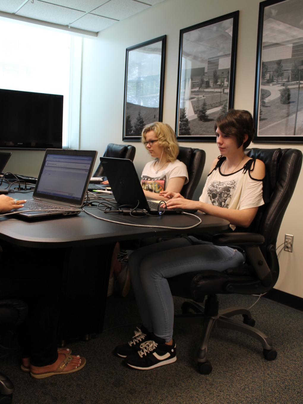 Bethany and Amber work on their laptops